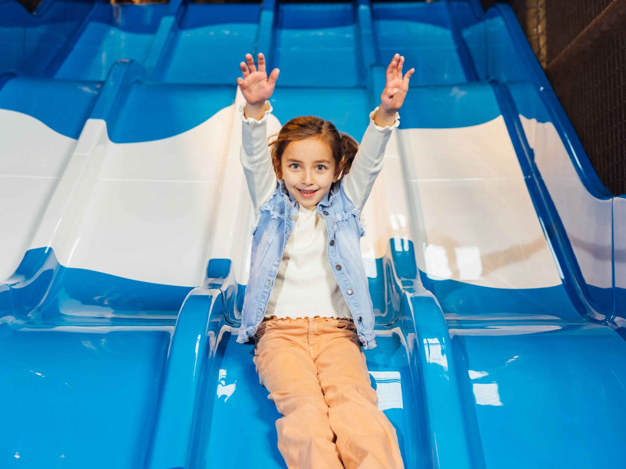 Een meisje gaat van de glijbaan in Speelland Indoor Beekse Bergen.