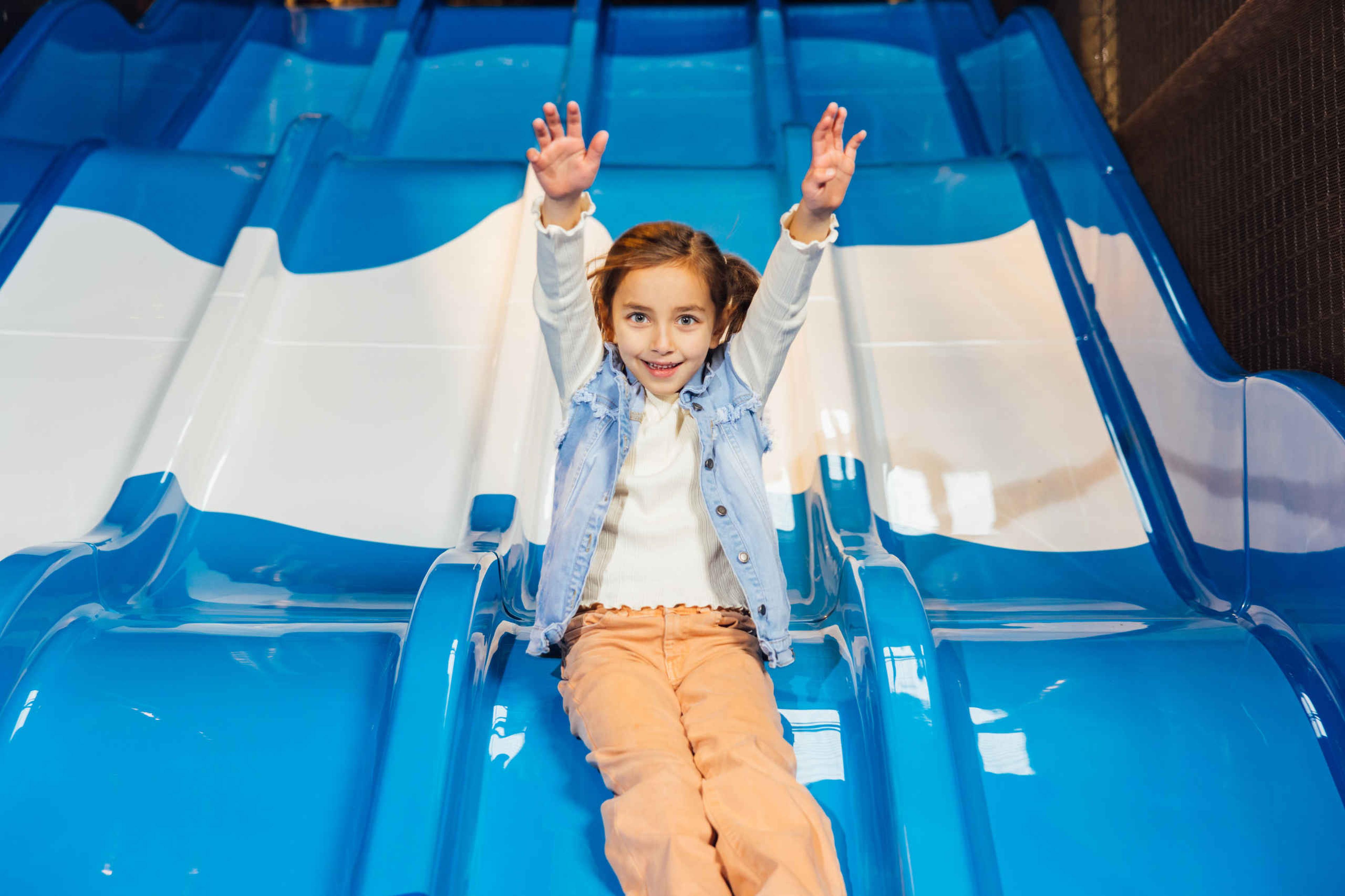 Een meisje gaat van de glijbaan in Speelland Indoor Beekse Bergen.