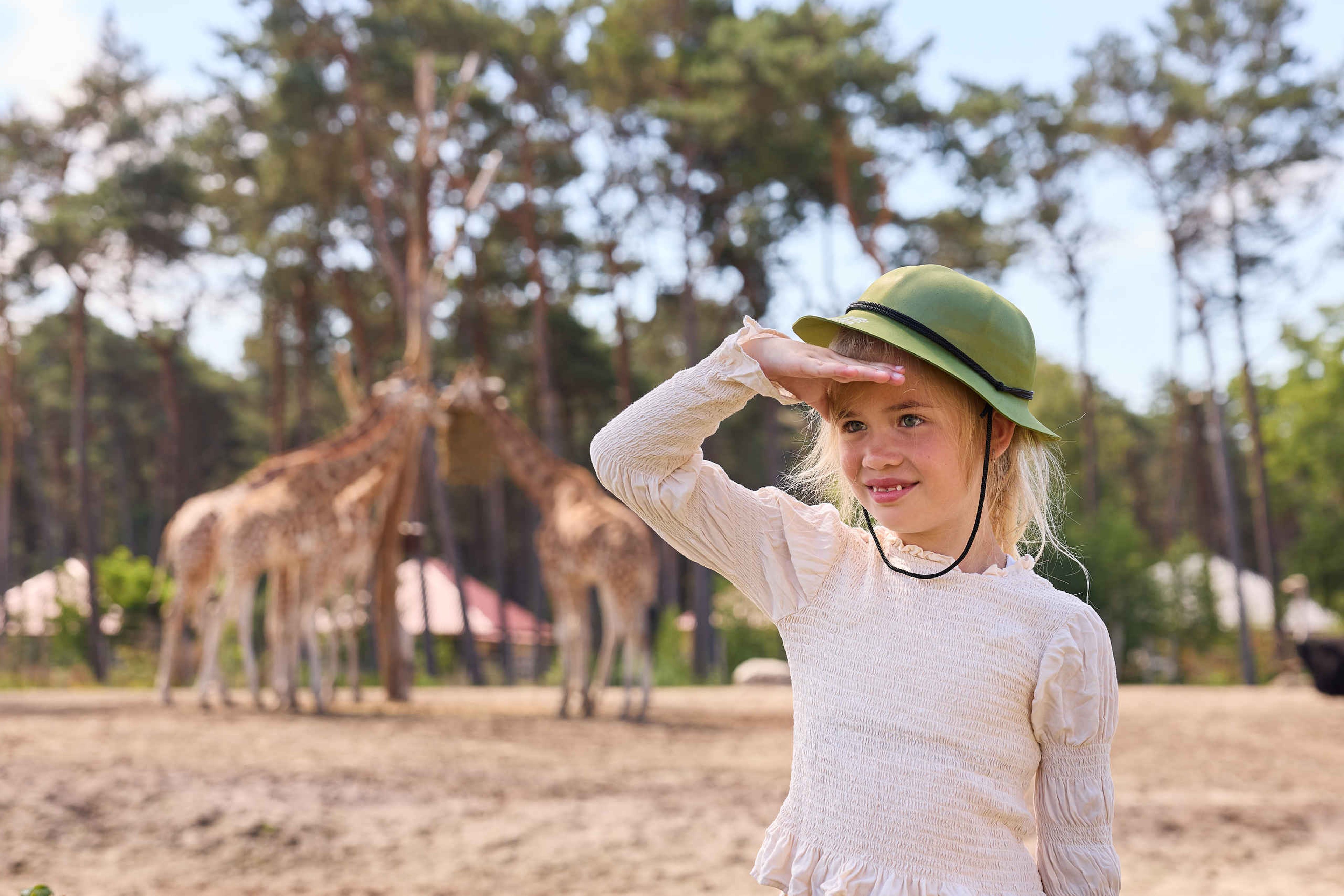 Kind met rangerhoedje bij de giraffen op Safari Resort Beekse Bergen