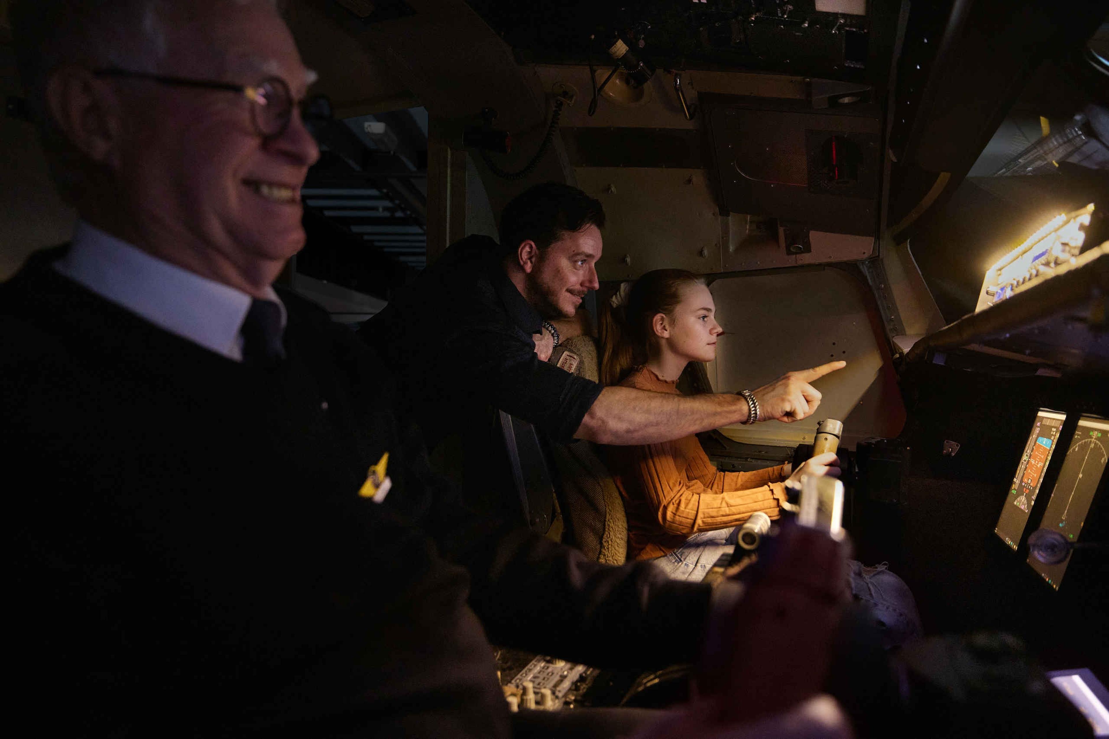 Kind en vrijwilliger binnen in de simulator bij Luchtvaartmuseum Aviodrome