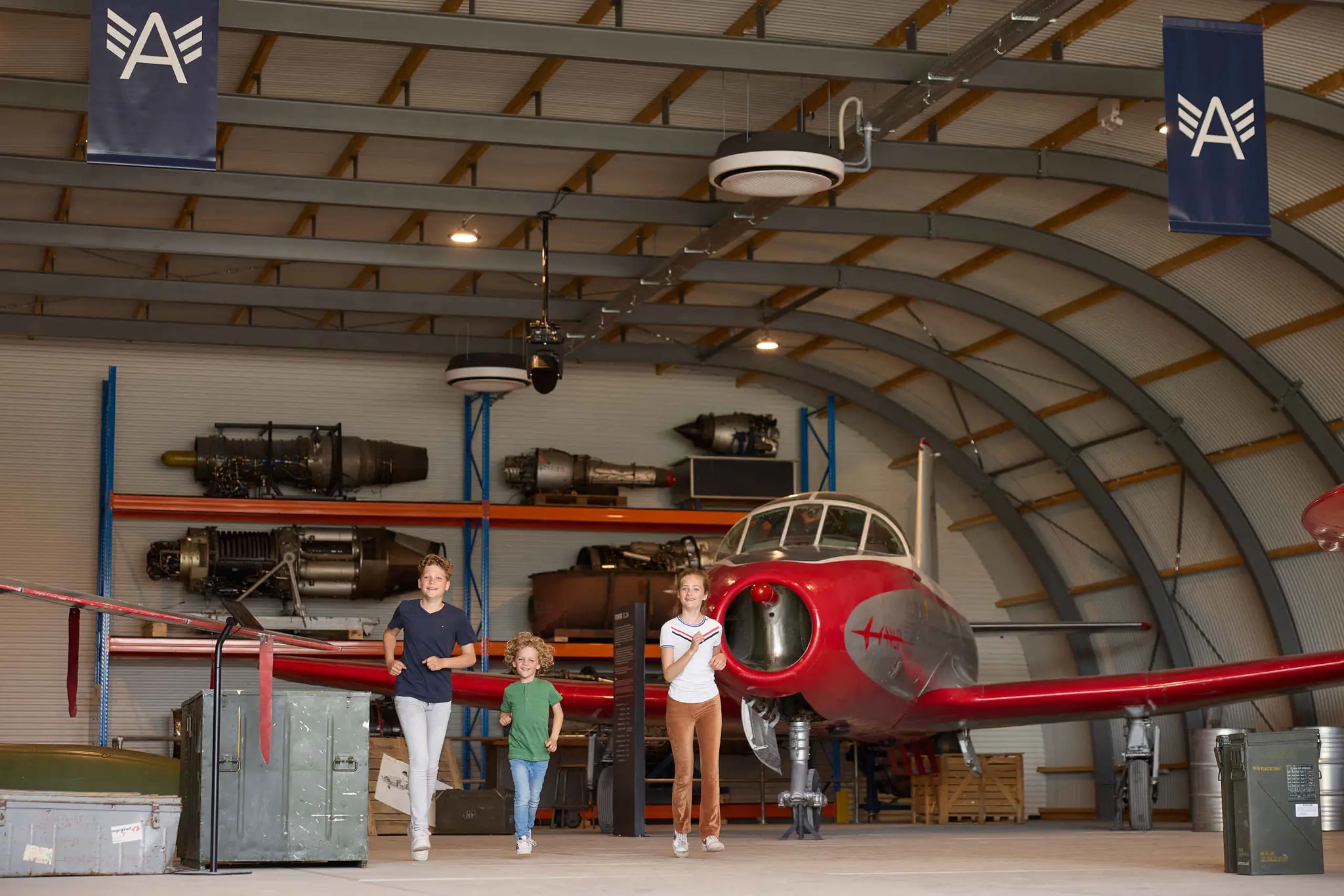 Drie kinderen rennen in de expositieruimte van Luchtvaartmuseum Aviodrome