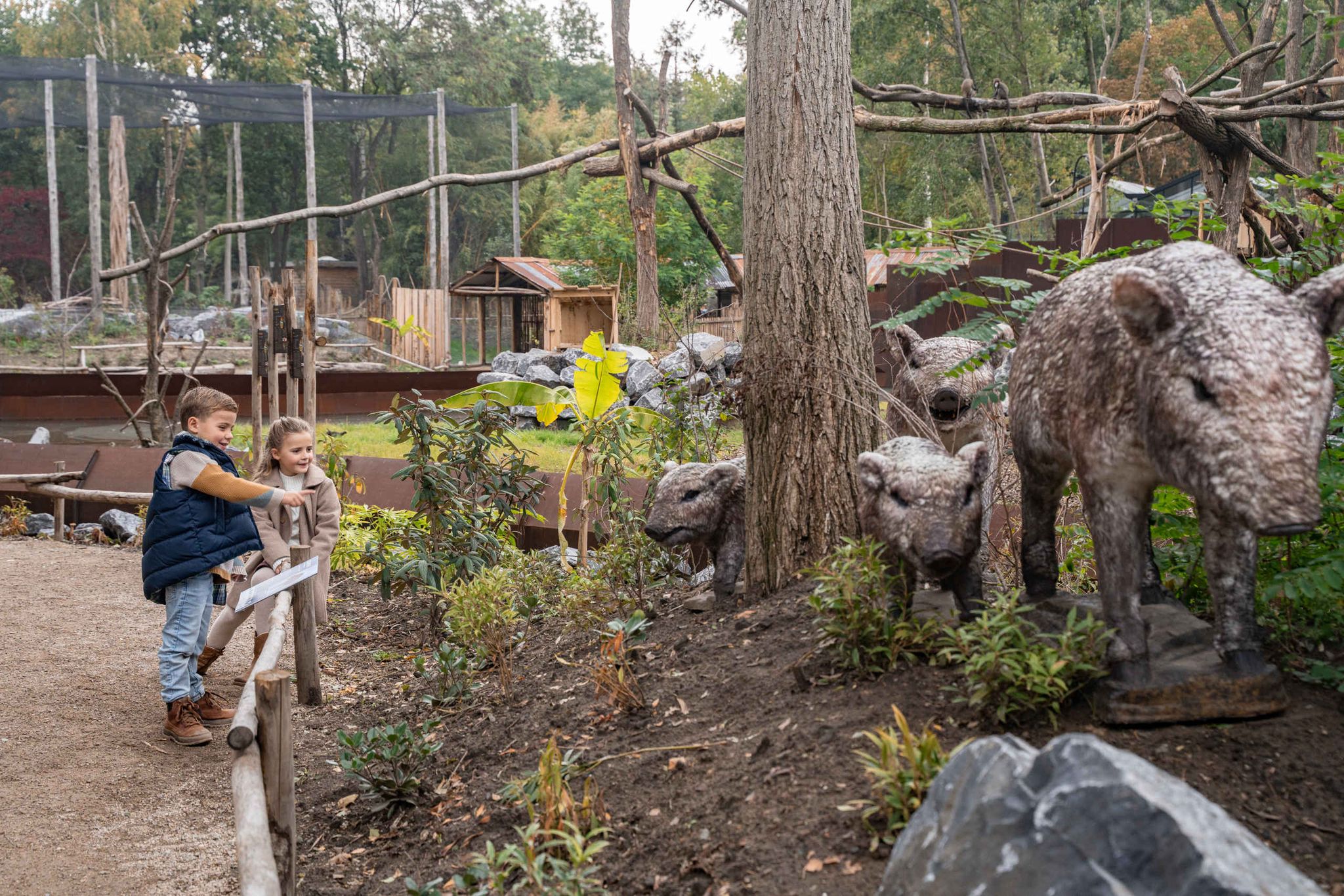 Twee kinderen kijken naar de Reuzenpekari tijdens het IJstijd evenement in ZooParc Overloon