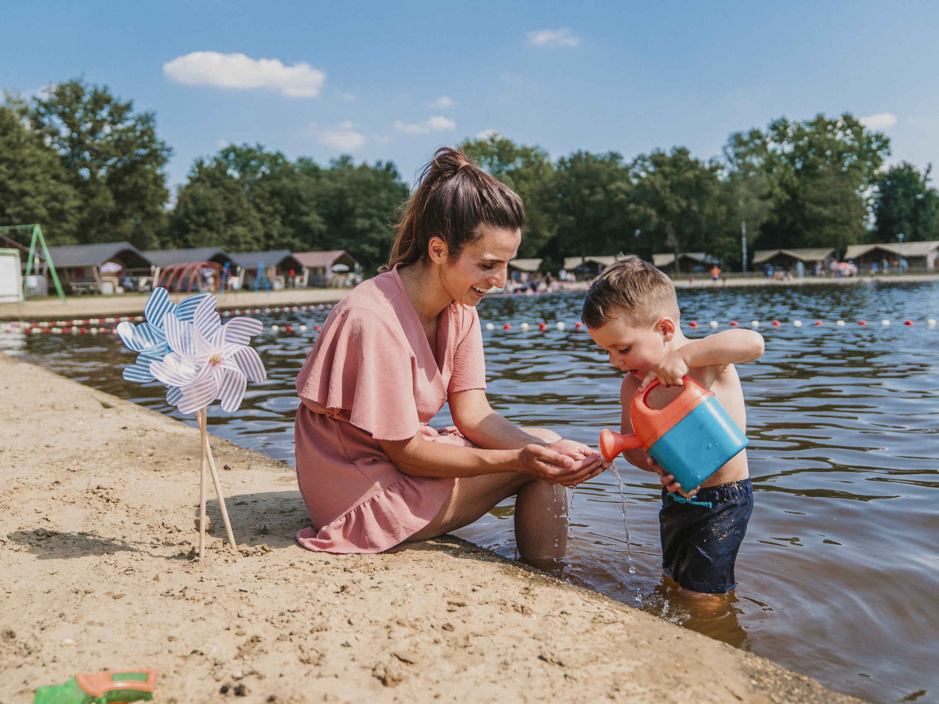 Een moeder en zoon spelen in de zwemvijver bij Vakantiepark Dierenbos