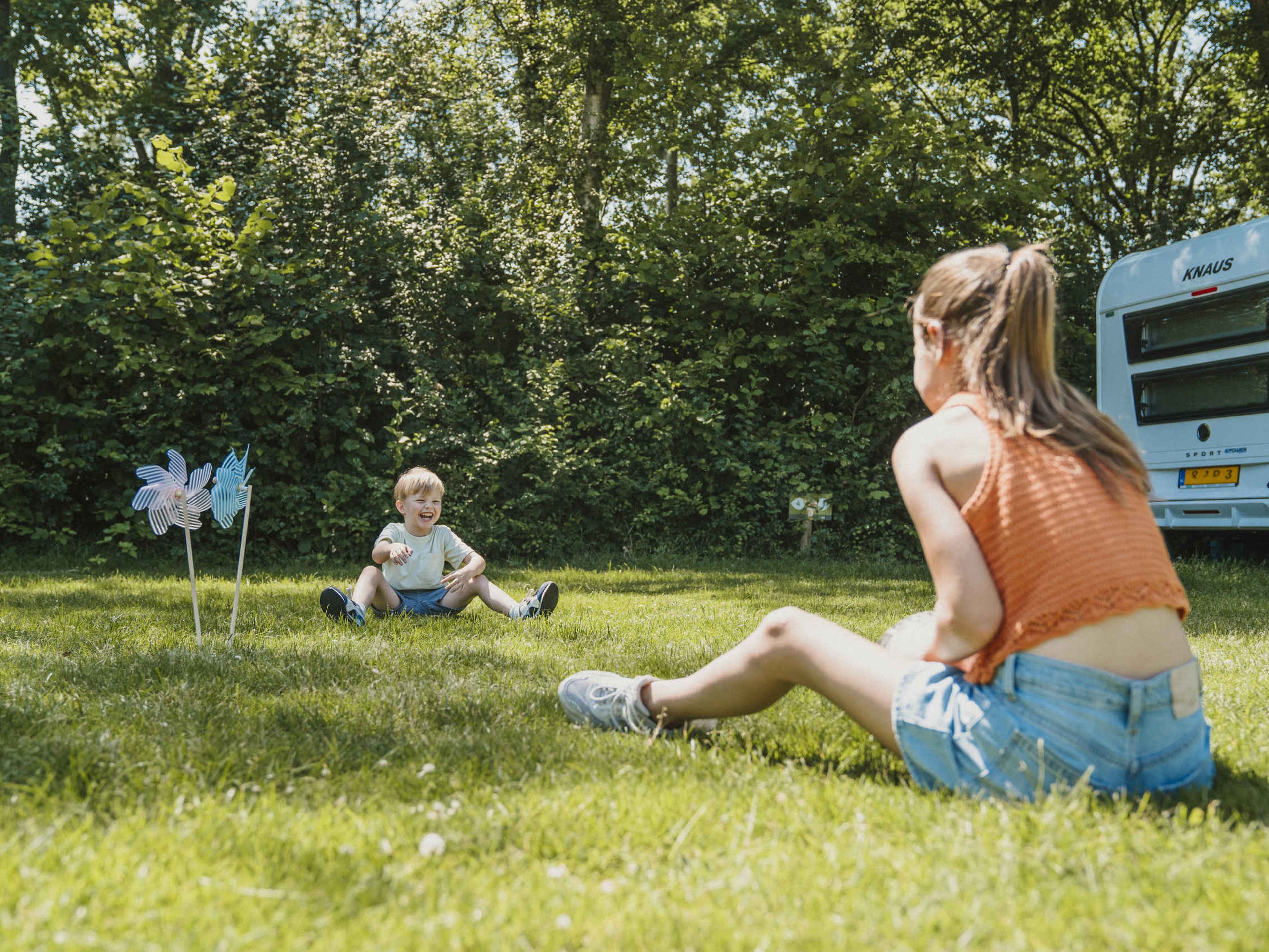 Een jongen en meisje voetballen op de kampeerplaats bij Vakantiepark Dierenbos