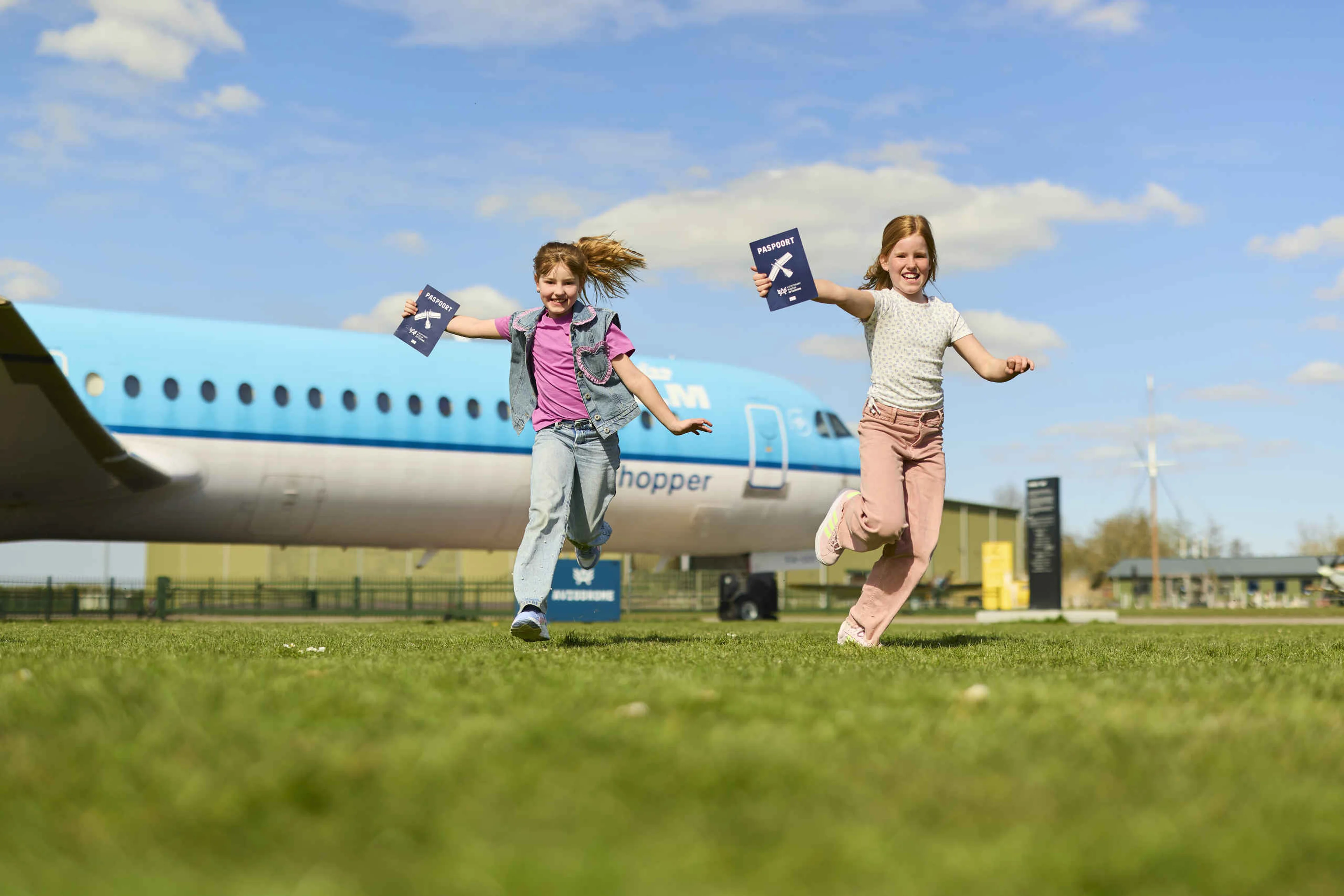 Twee meisjes rennen op het buitenterrein tijdens Destination Aviodrome bij Luchtvaartmuseum Aviodrome