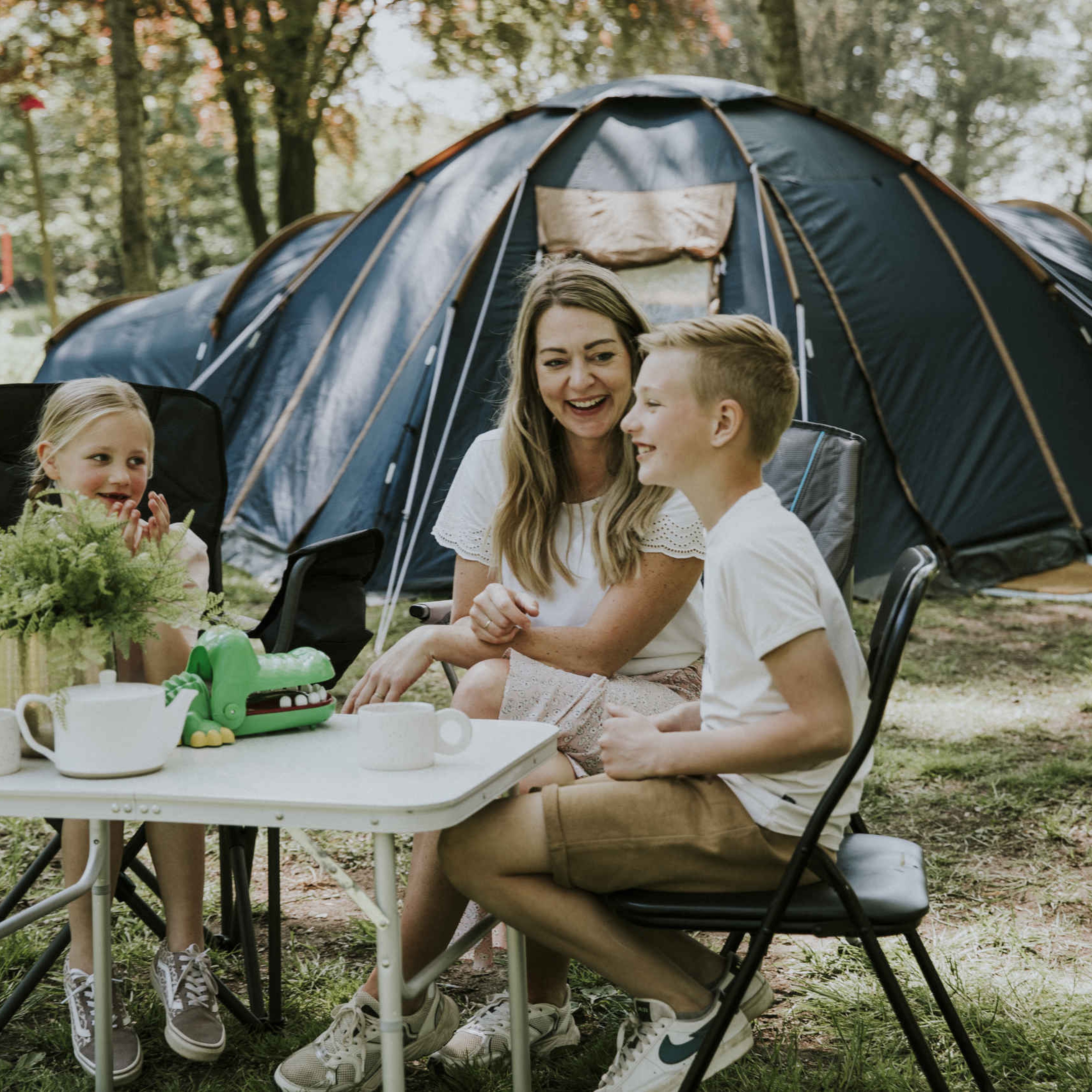 Gezin speelt een spelletje op belevingskampeerplaats op Vakantiepark Dierenbos