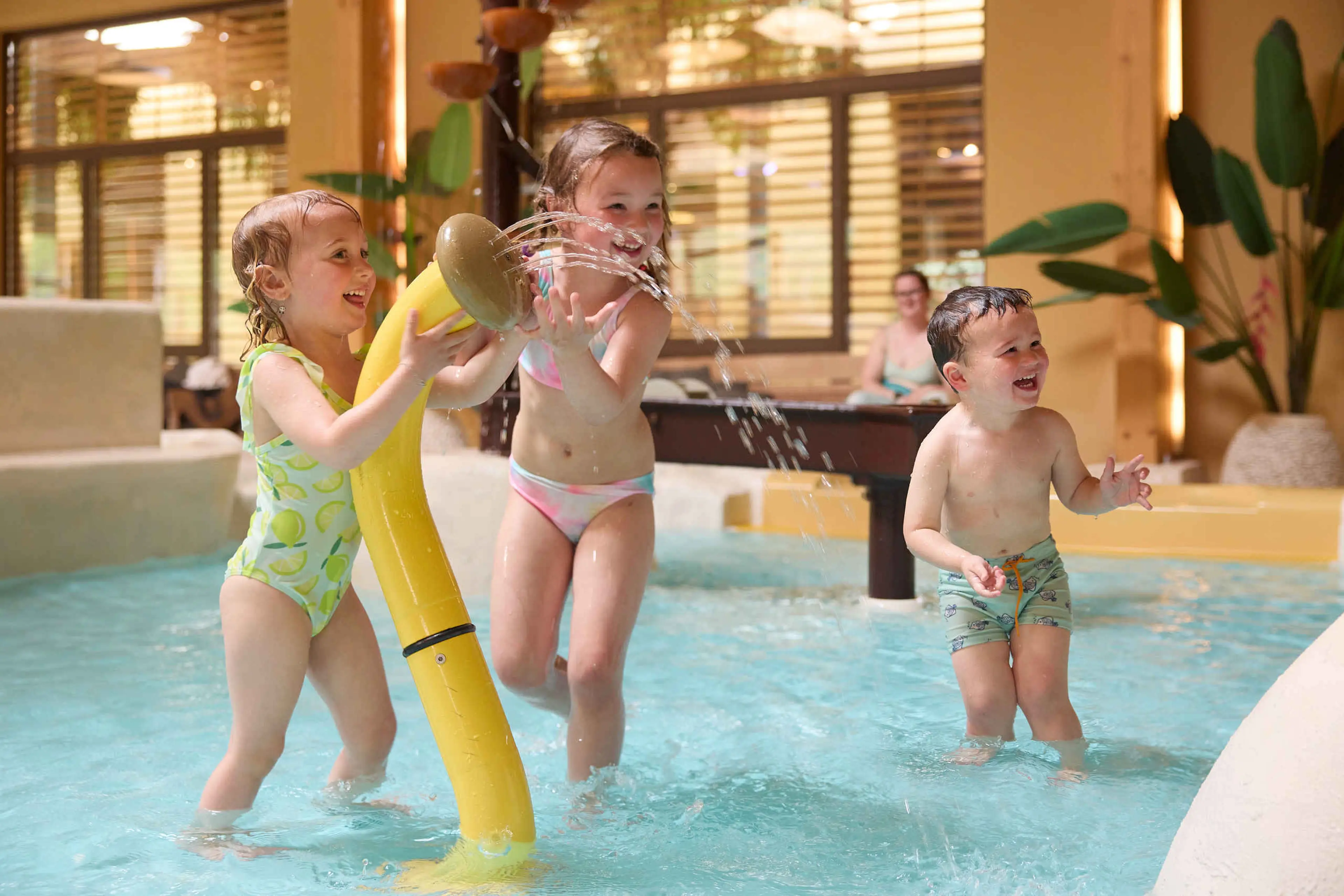 Drie kinderen spelen in het kinderbad bij zwembad Maji Springs op Safari Resort Beekse Bergen.
