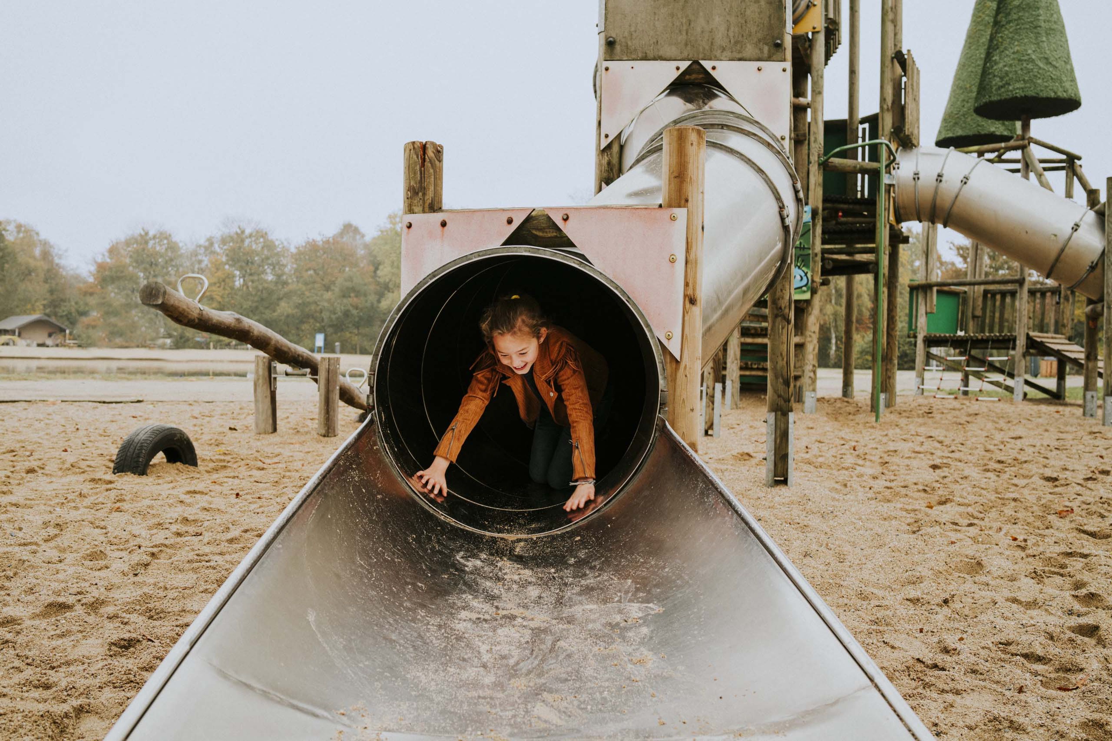 Kind op de glijbaan in de speeltuin van Vakantiepark Dierenbos