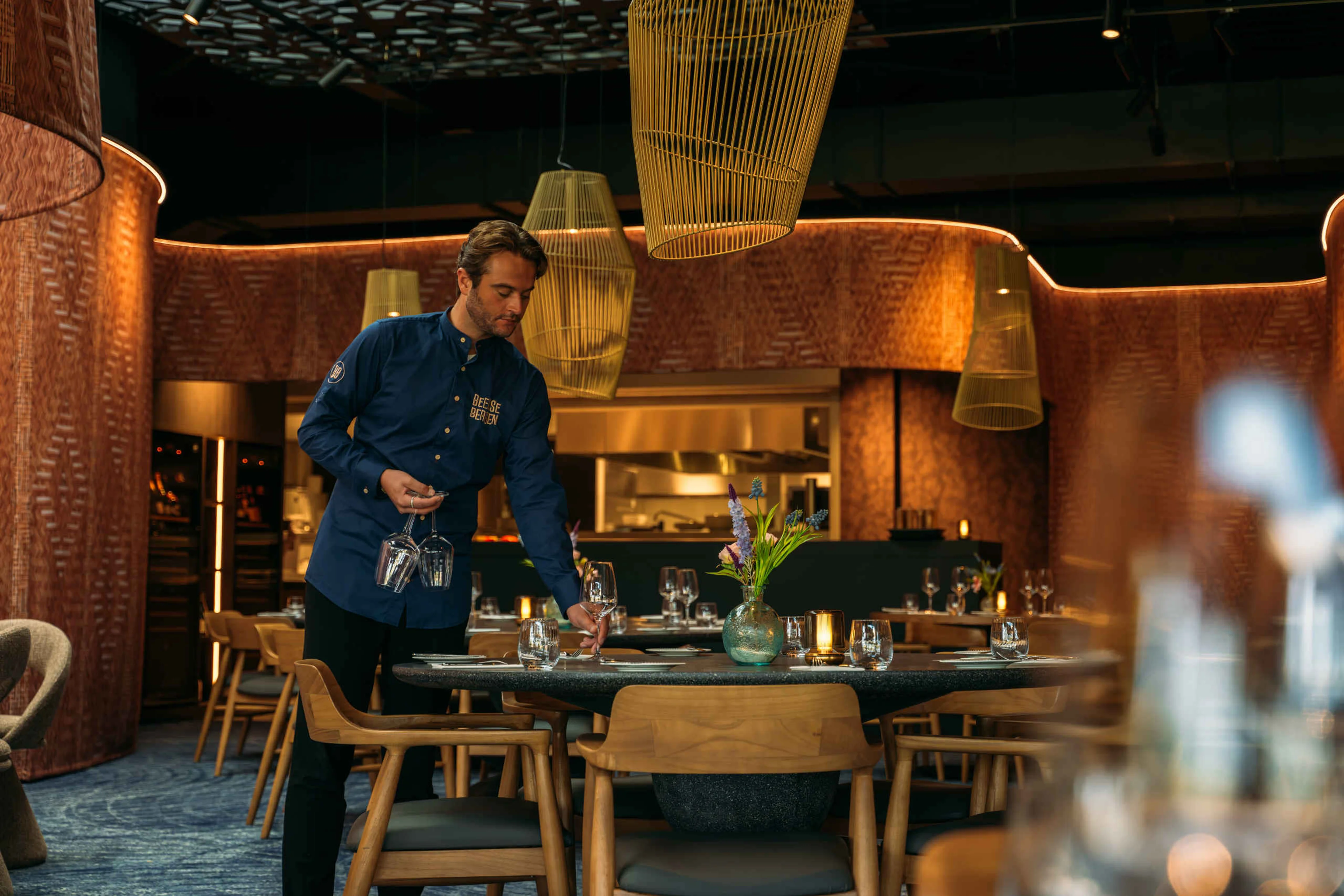 Wijnglazen worden op tafel geplaatst door medewerker in Bar & Restaurant Nommos