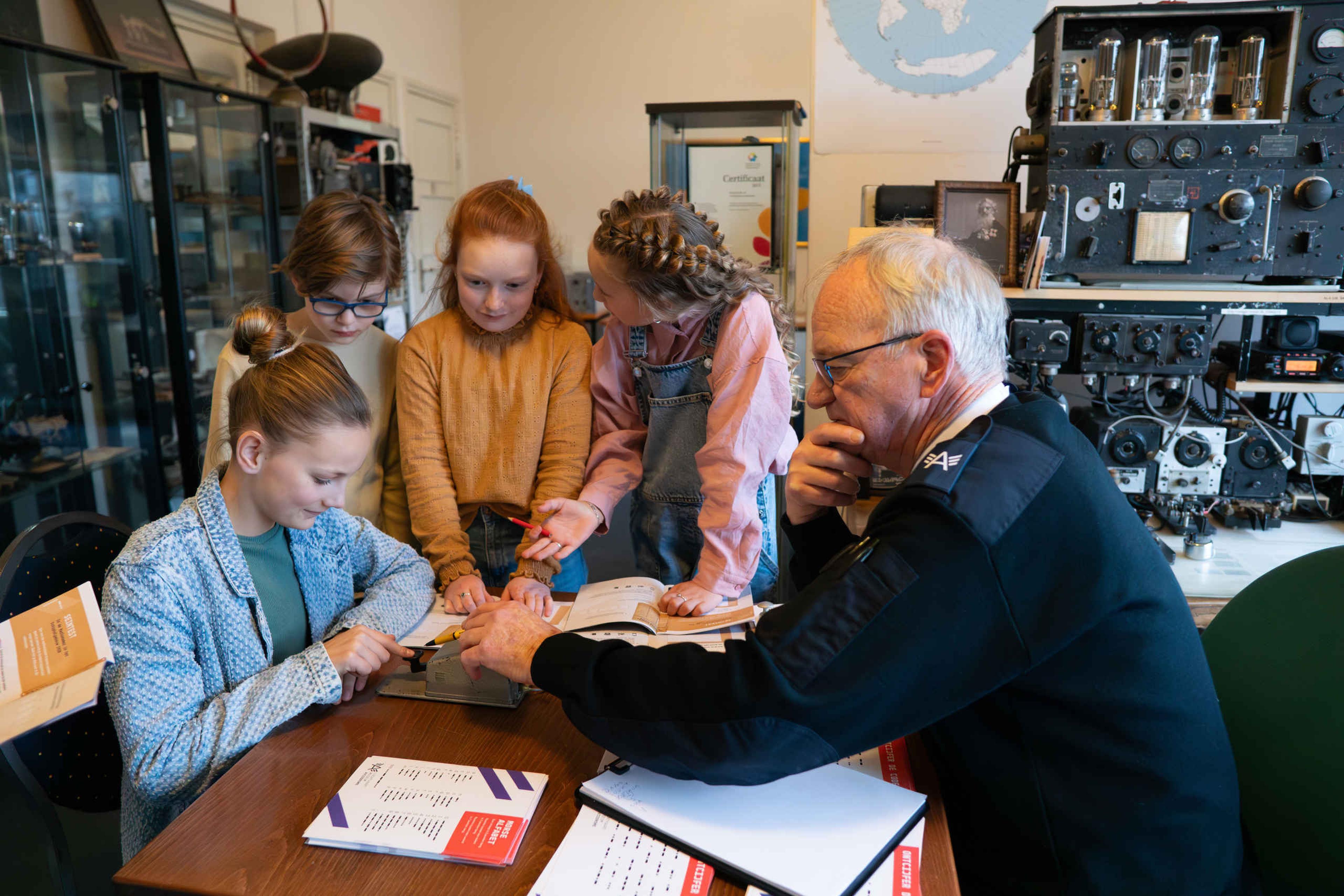 Vrijwilliger met kinderen in Luchtvaartmuseum Aviodrome