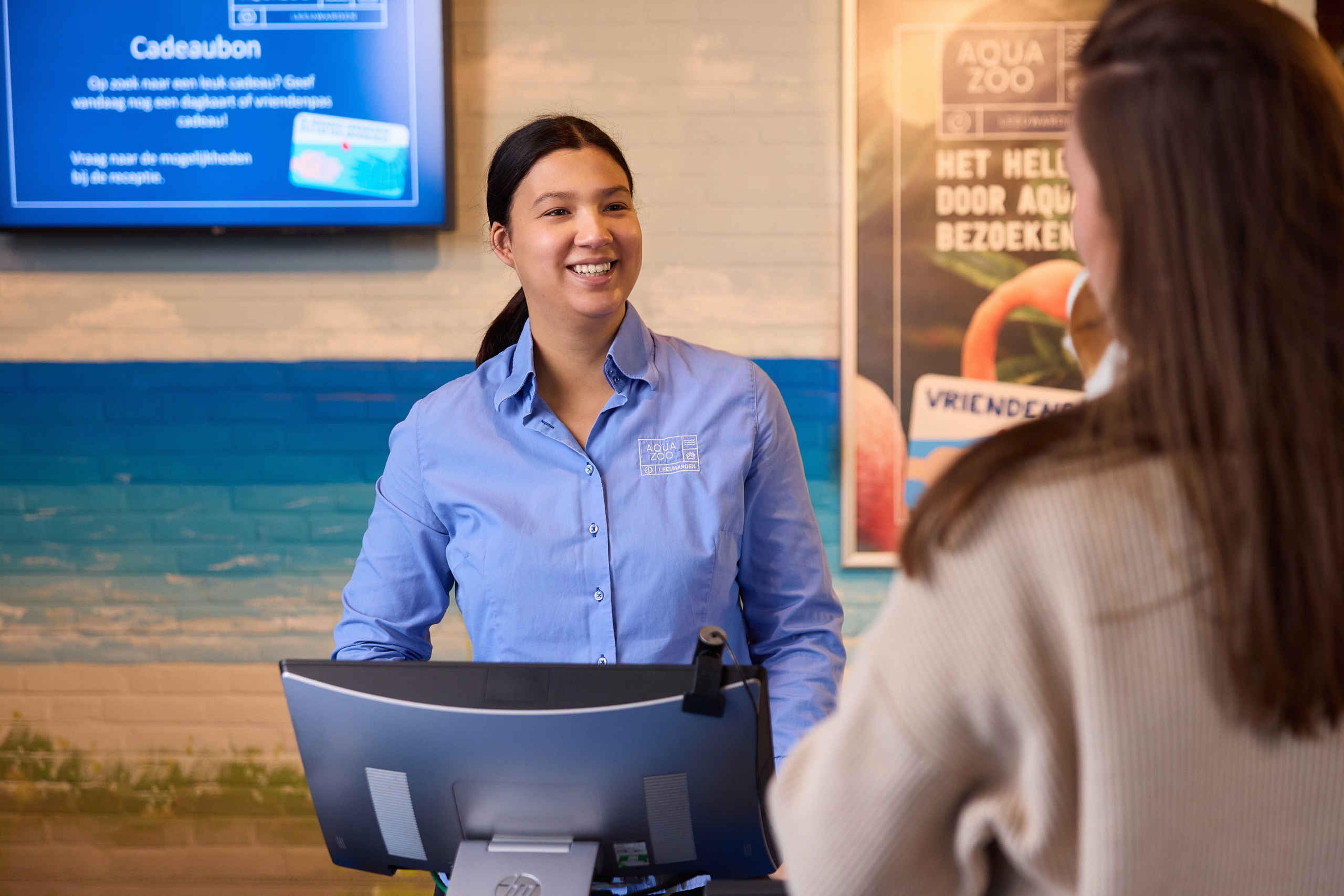 Een medewerker bij de receptie van AquaZoo Leeuwarden