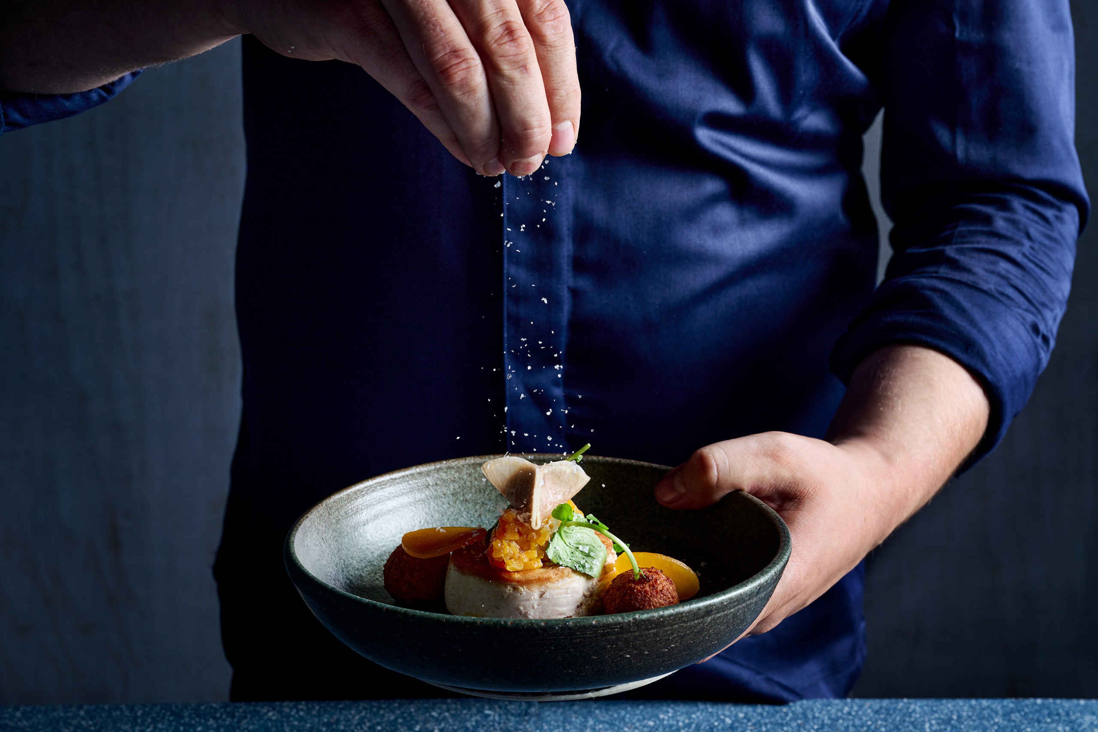 De chefkok maakt een gerecht af bij Bar & Restaurant Nommos.