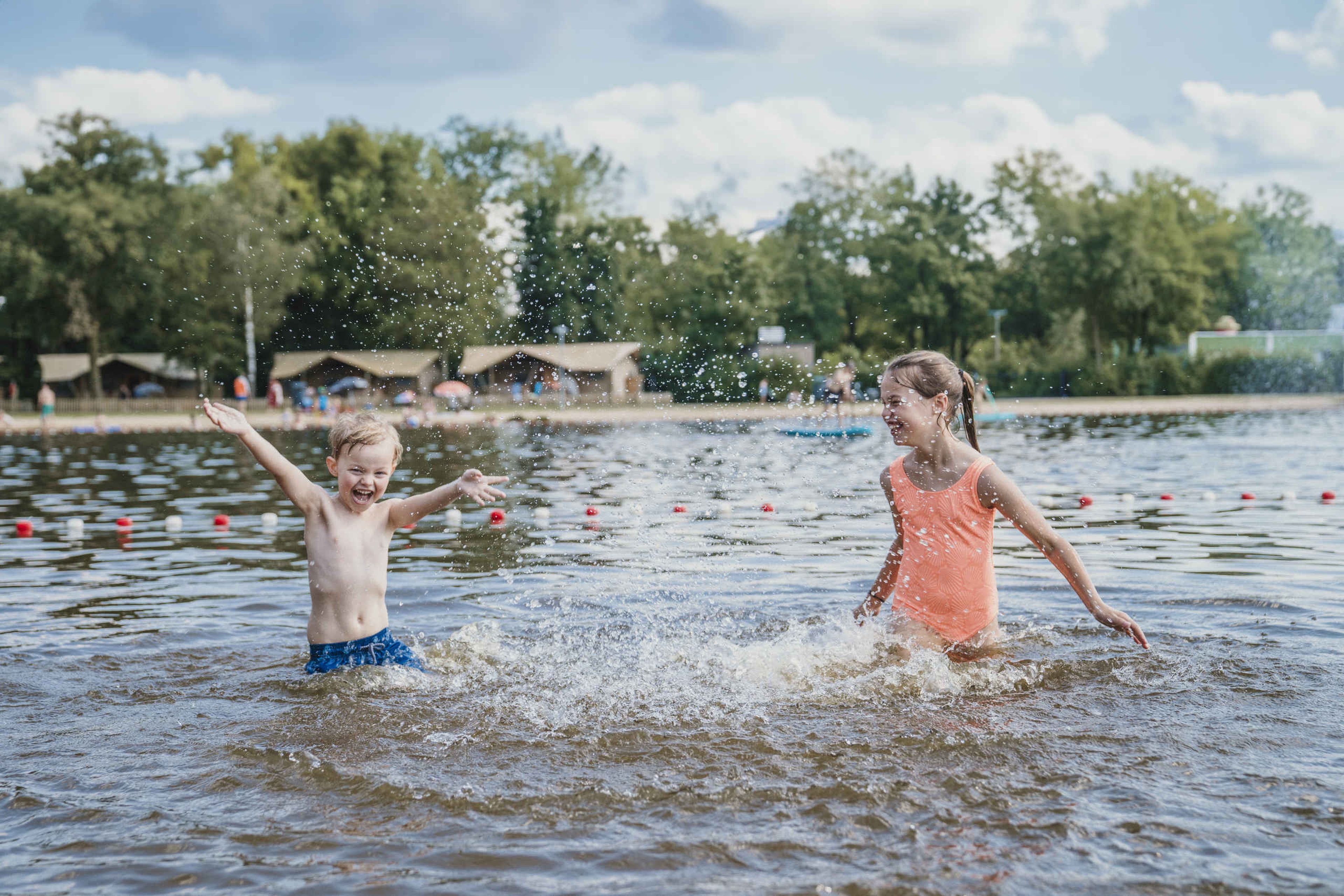 Een jongen en een meisje spelen in de zwemvijver bij Vakantiepark Dierenbos
