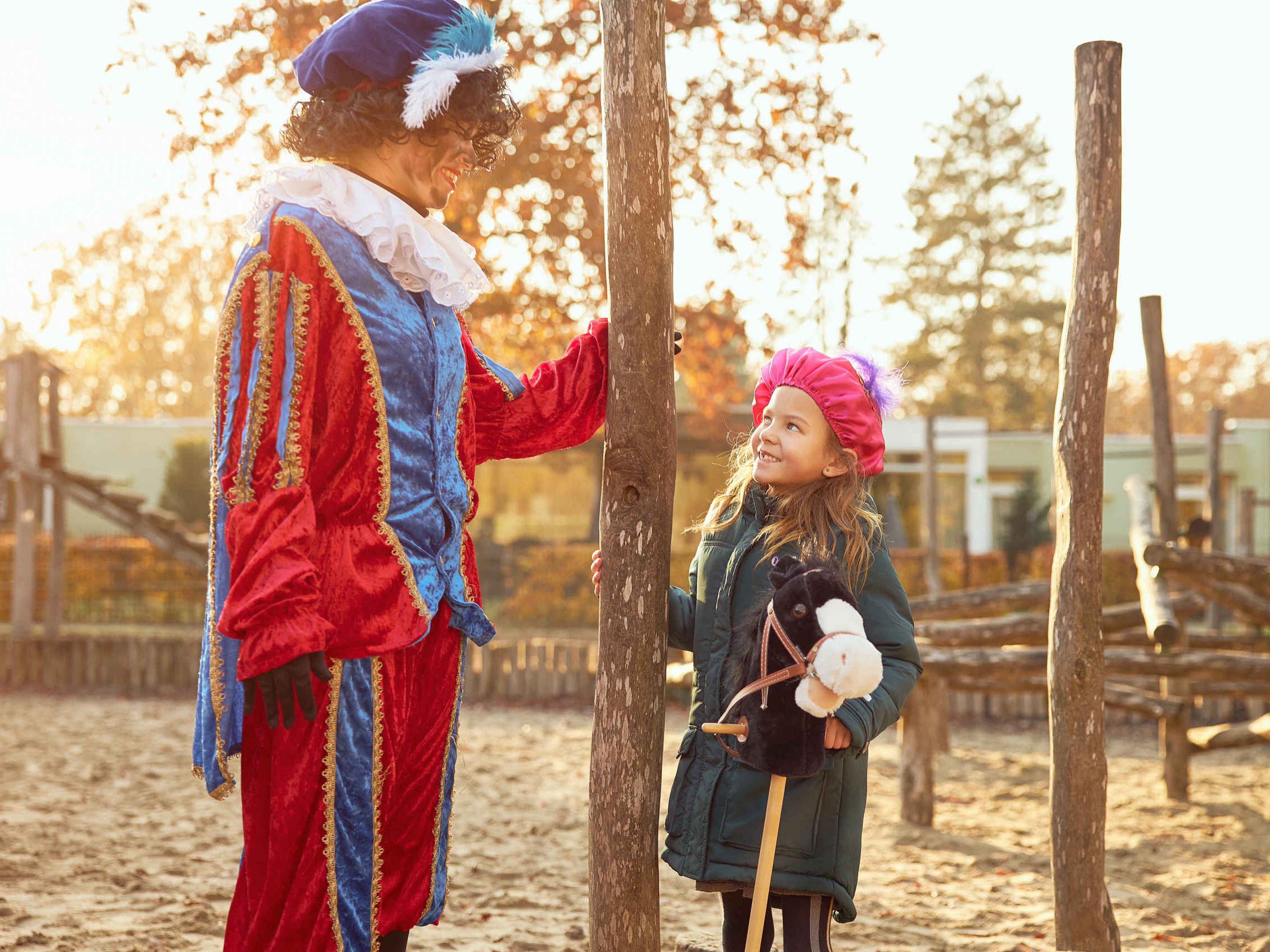 Piet en meisje spelen tijdens Sinterklaas in de speeltuin op Vakantiepark Dierenbos