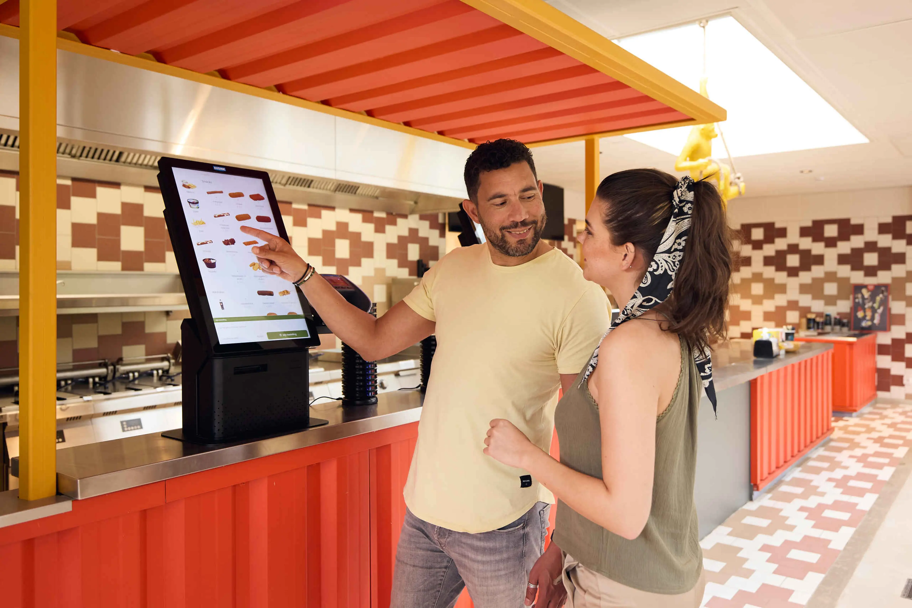 Een stel besteld friet en een snack bij de bestelzuil van Jaaba Counter bij Lake Resort Beekse Bergen.