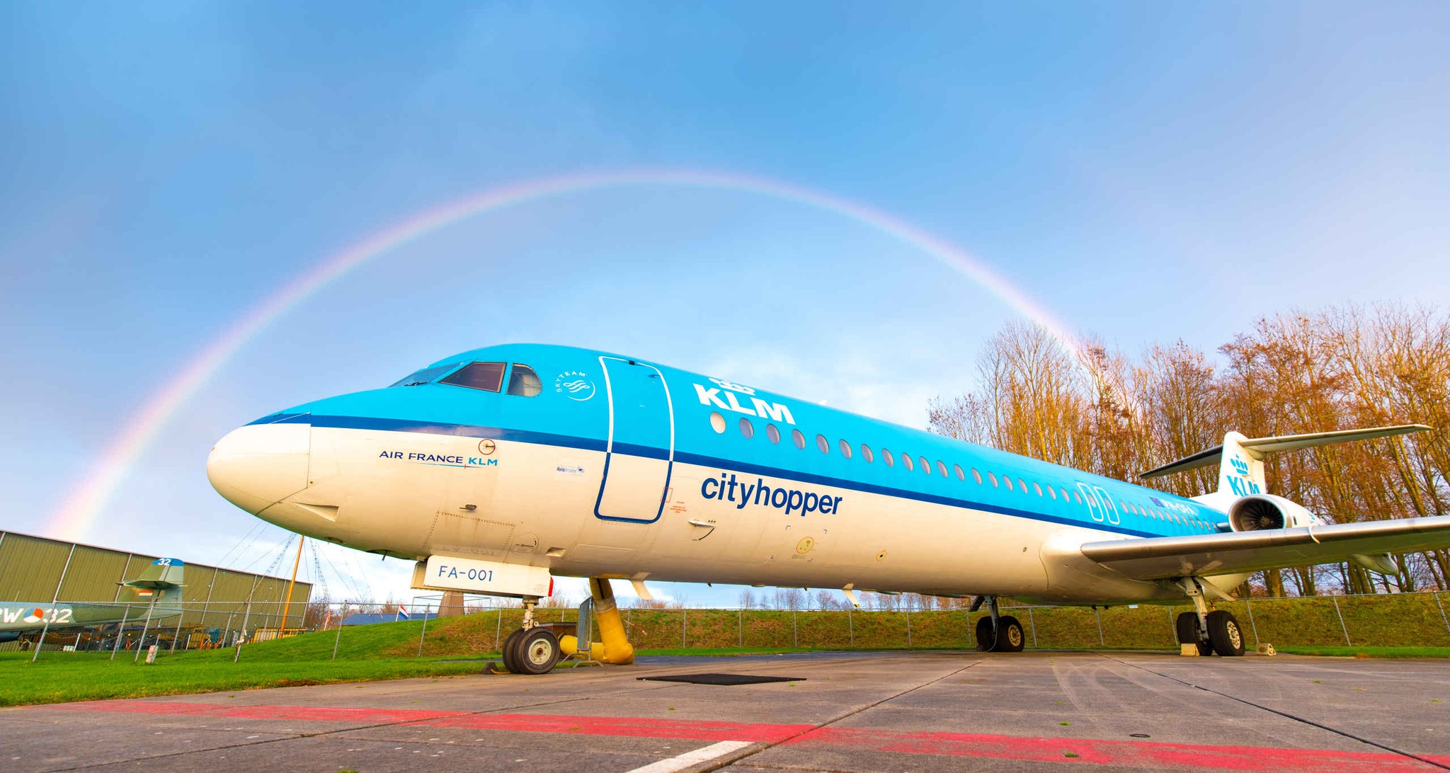 Een KLM cityhopper onder een regenboog op het buitenterrein van Luchtvaartmuseum Aviodrome