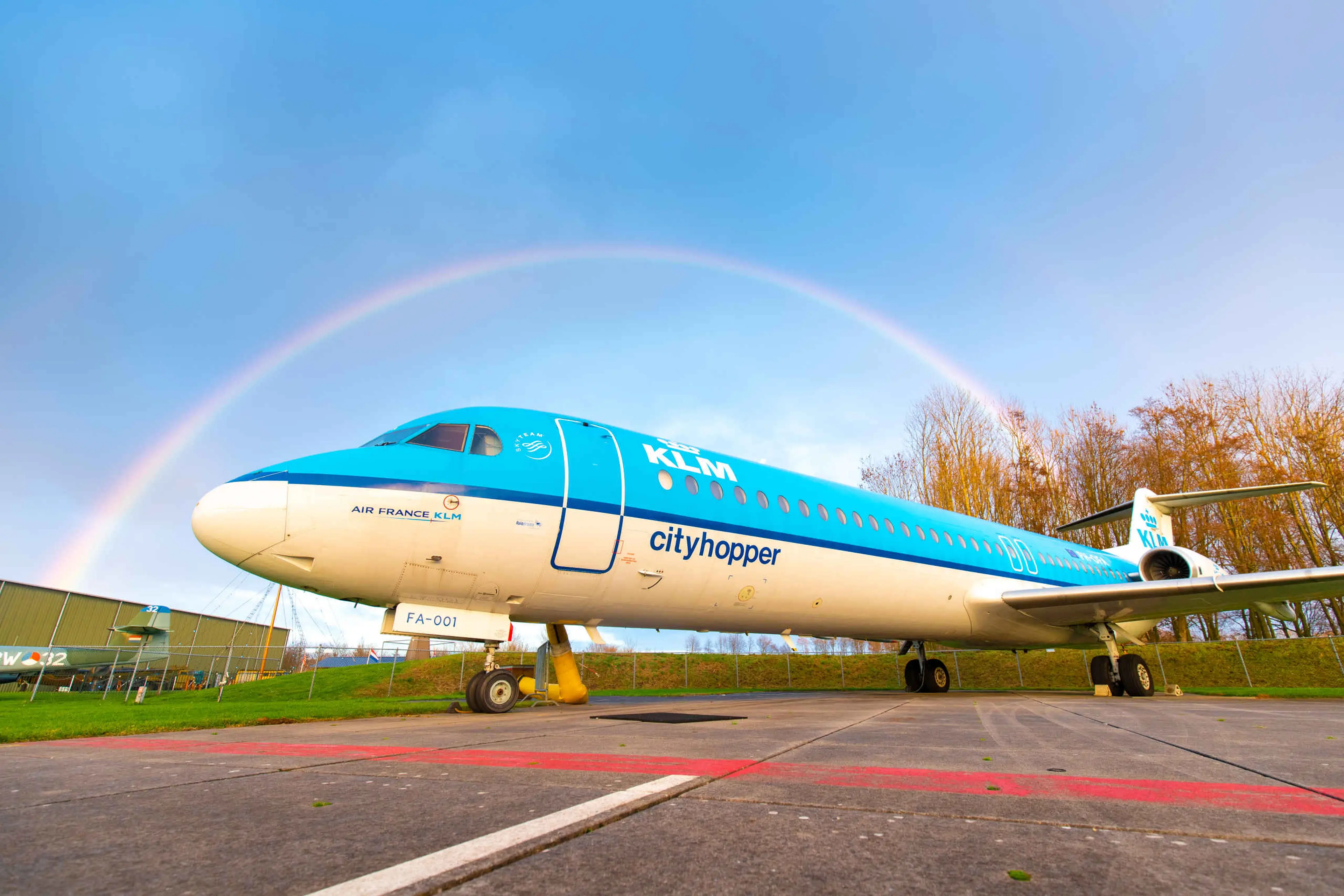 Een KLM cityhopper onder een regenboog op het buitenterrein van Luchtvaartmuseum Aviodrome