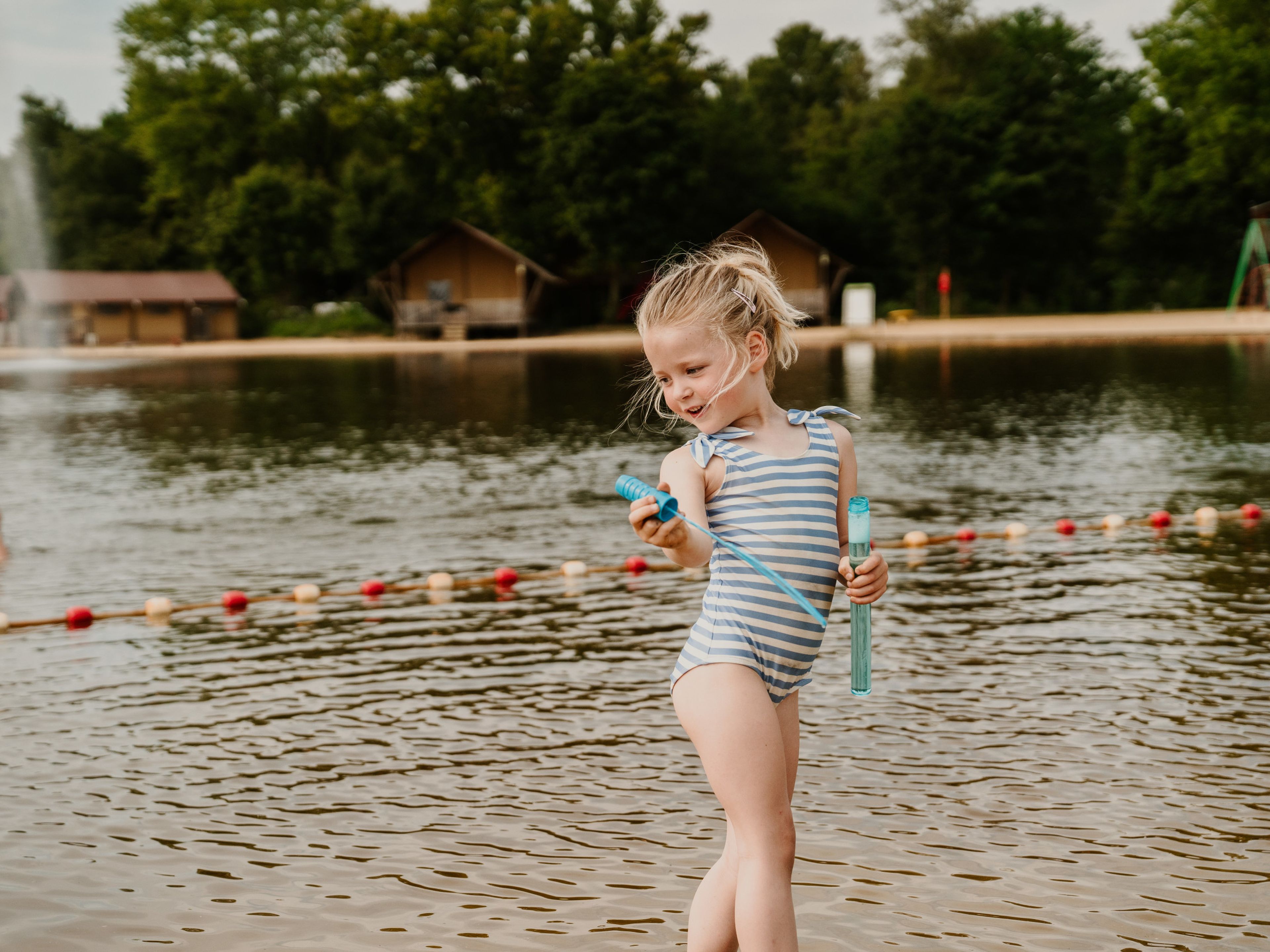 Meisje aan het spelen met bellenblaas bij de zwemvijver van Vakantiepark Dierenbos
