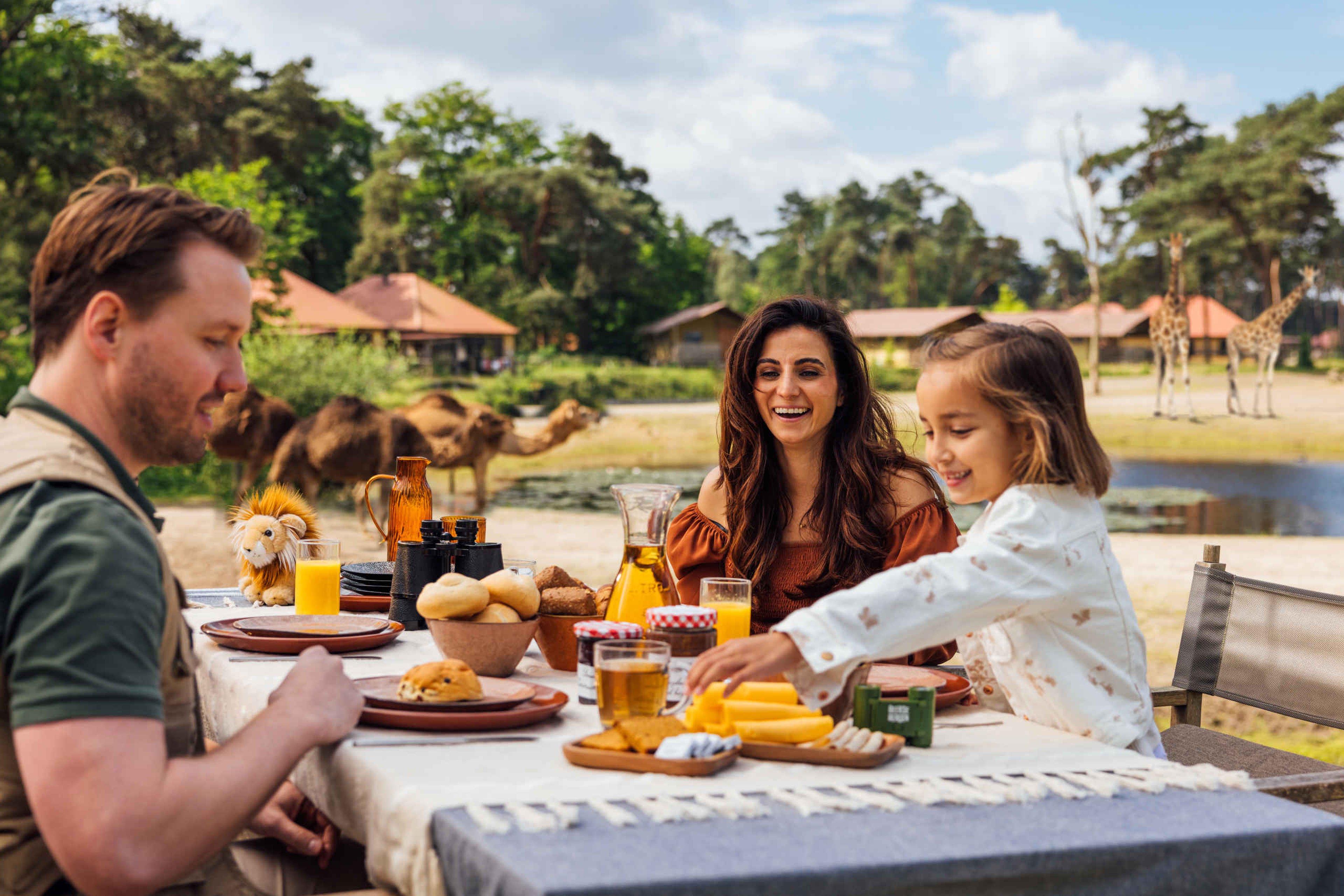 Een gezin zit te ontbijten bij hun vakantiehuisje op Safari Resort Beekse Bergen.