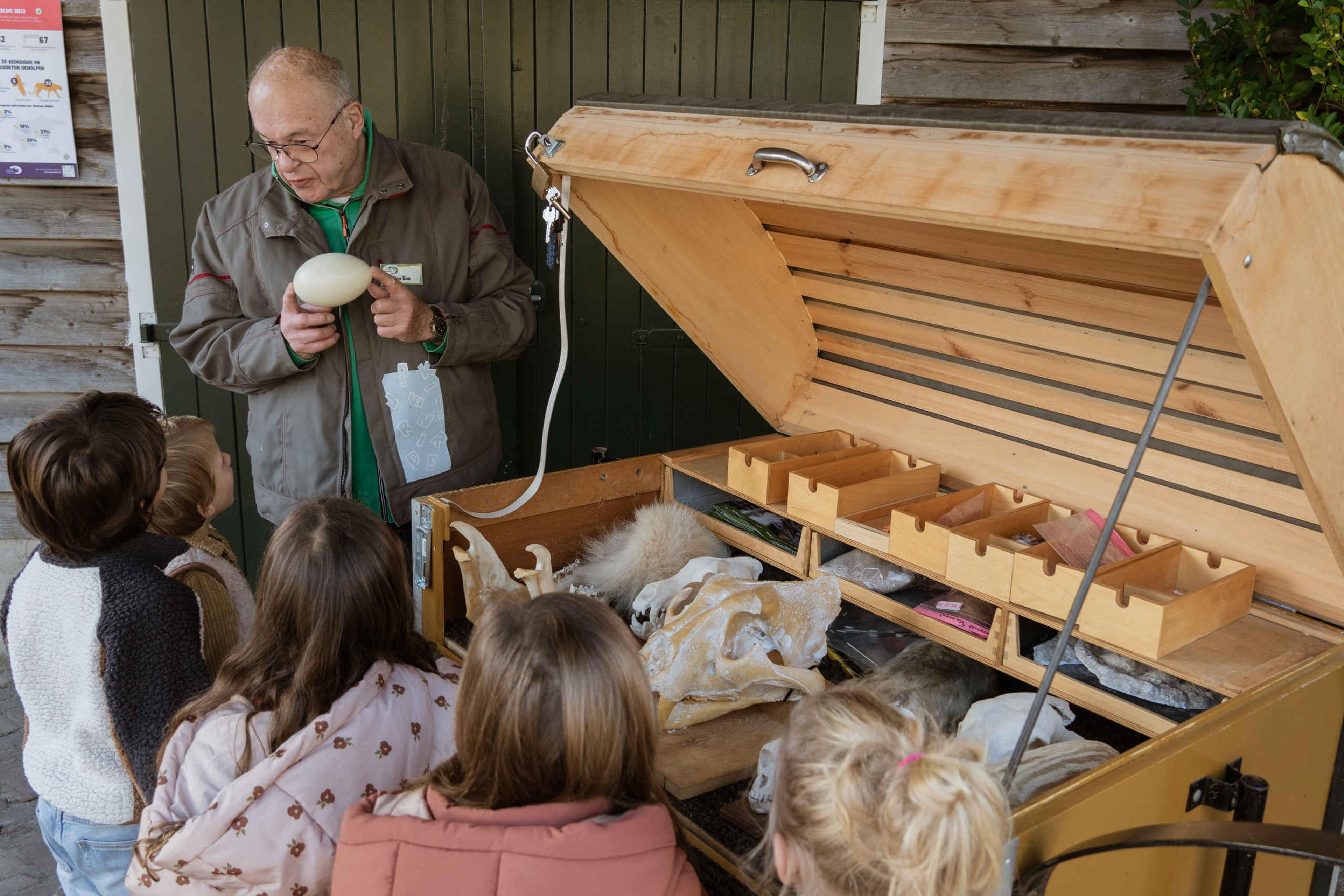Een vrijwilliger van Stichting Wildlife vertelt een groep kinderen over de verschillende dieren bij Eindhoven Zoo.