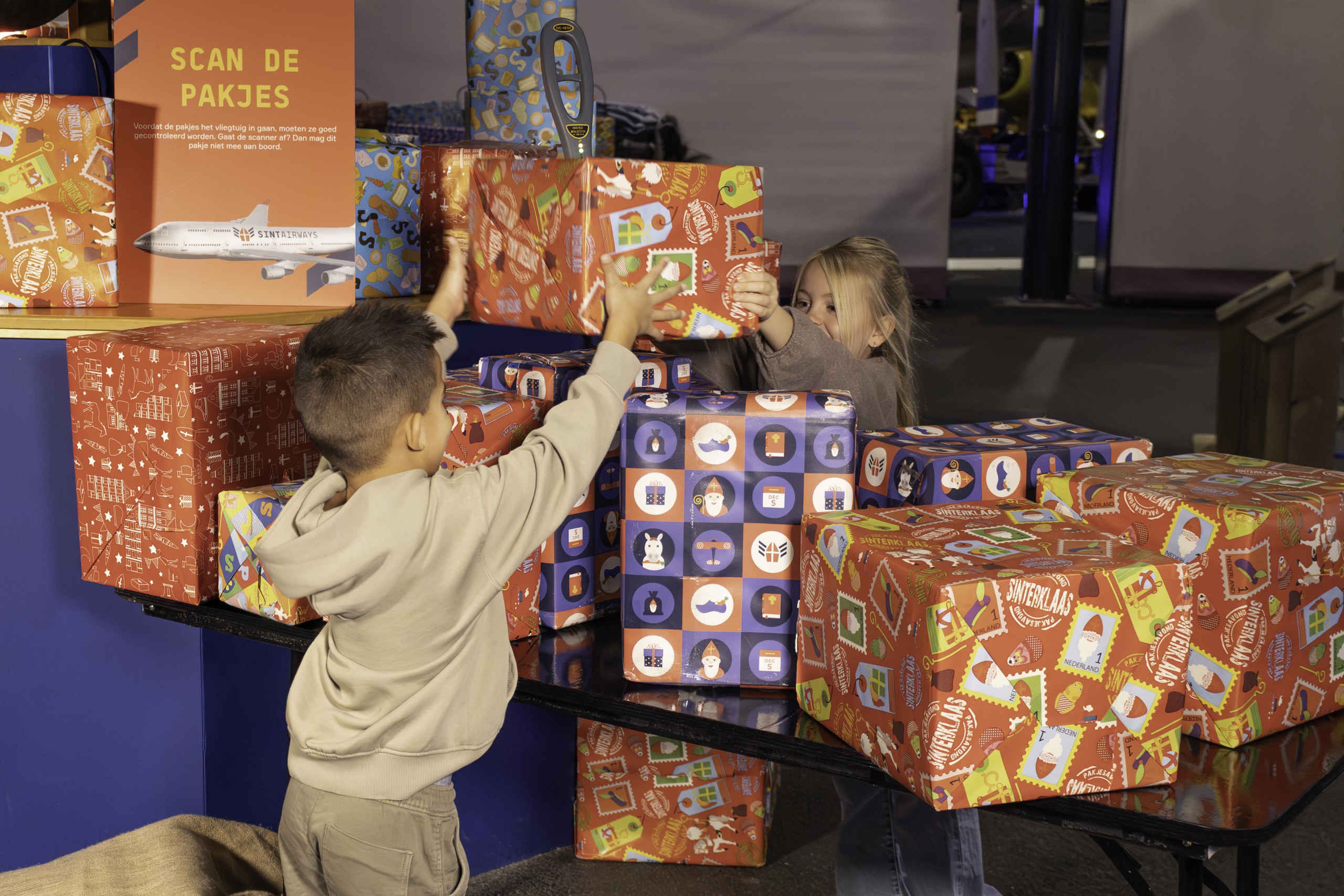 Kinderen scannen pakjes tijdens SintAIRklaas bij Aviodrome
