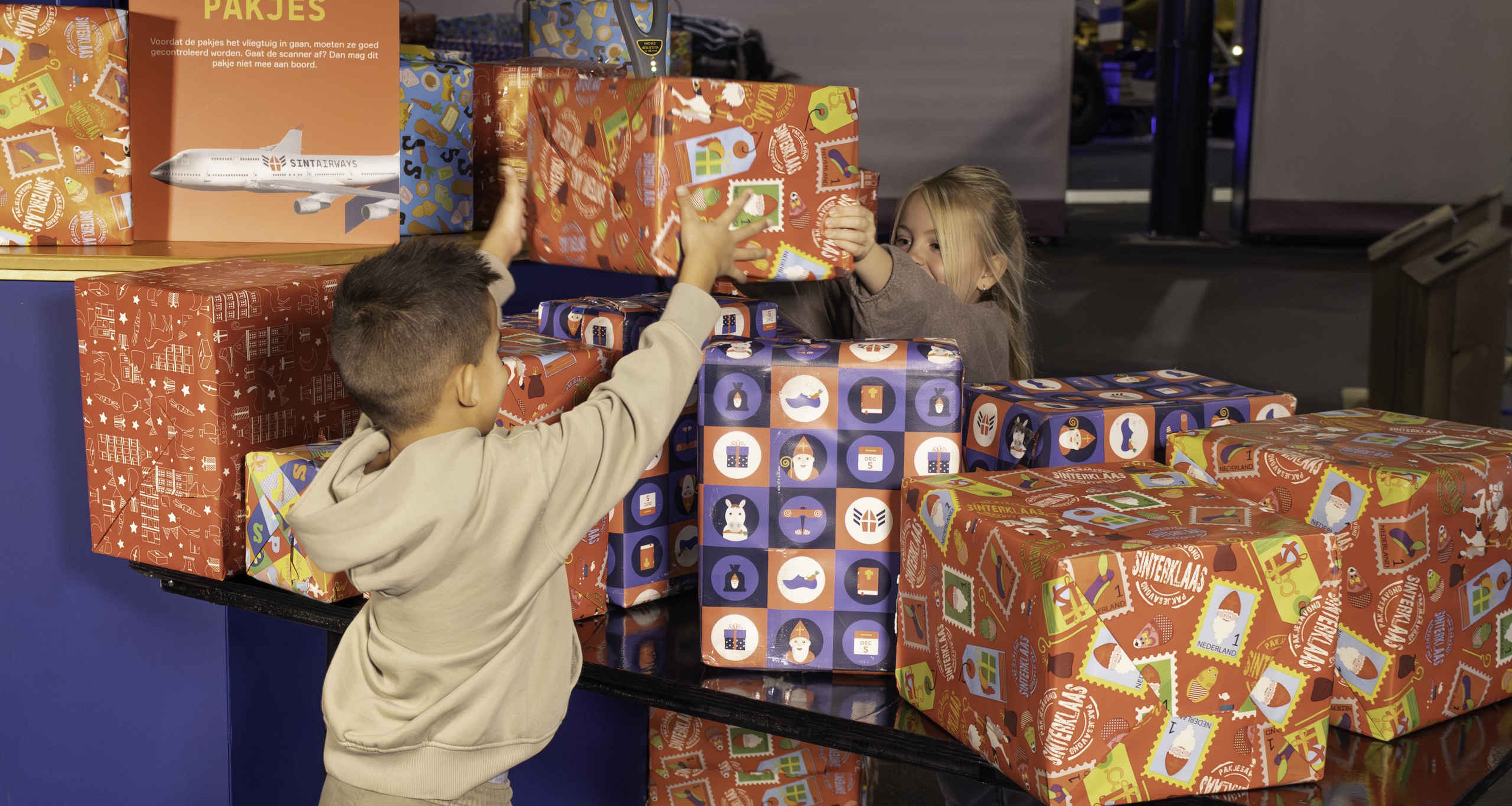 Kinderen scannen pakjes tijdens SintAIRklaas bij Aviodrome