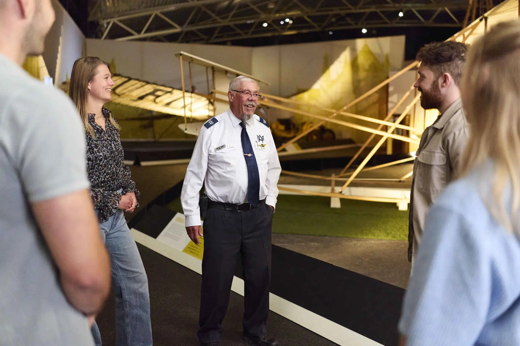Een vrijwilliger geeft een zaklijke rondleiding aan een groep collega's in Luchtvaartmuseum Aviodrome