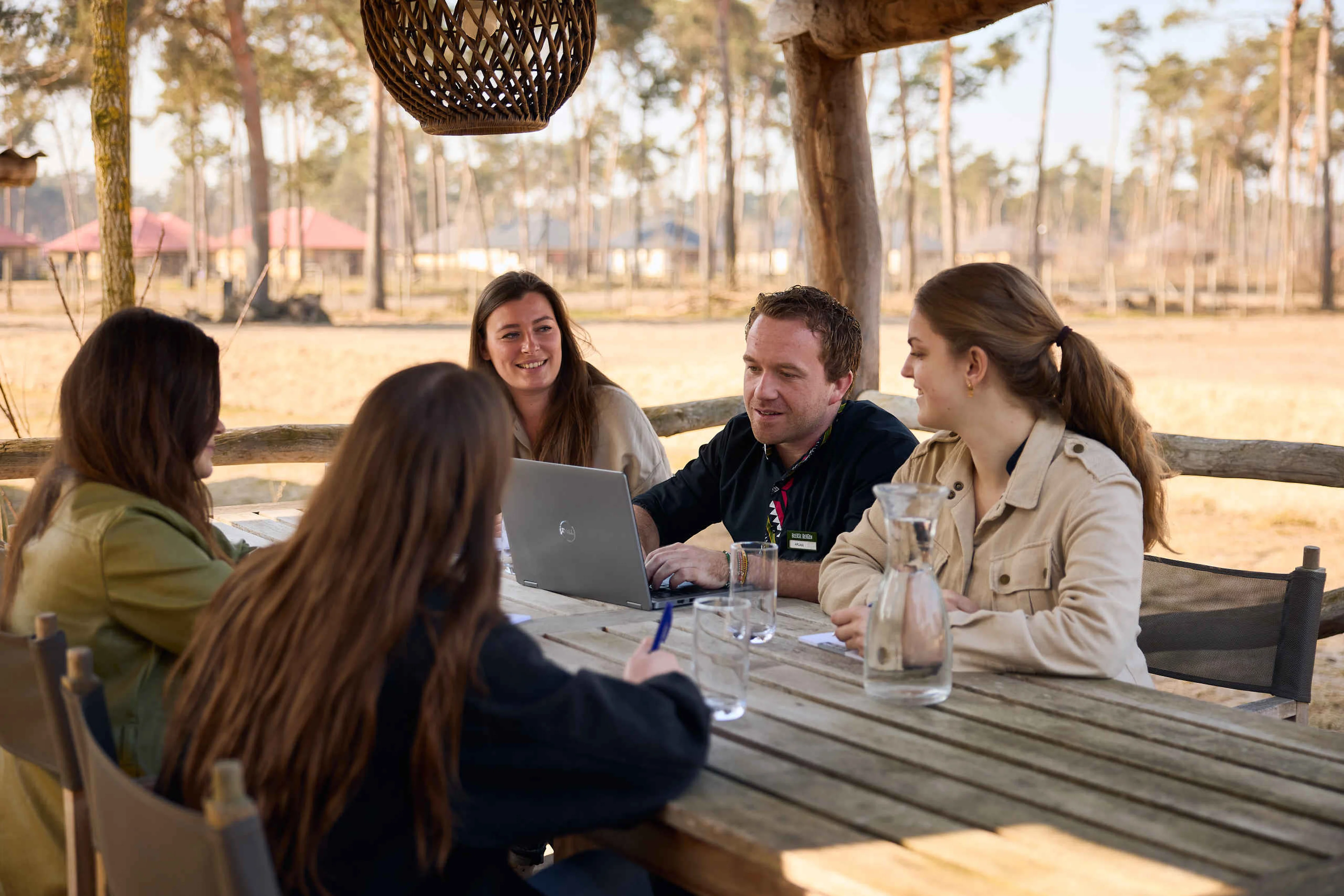 Een groep collega's tijdens een vergadering op het terras van het Safari Resort Beekse Bergen