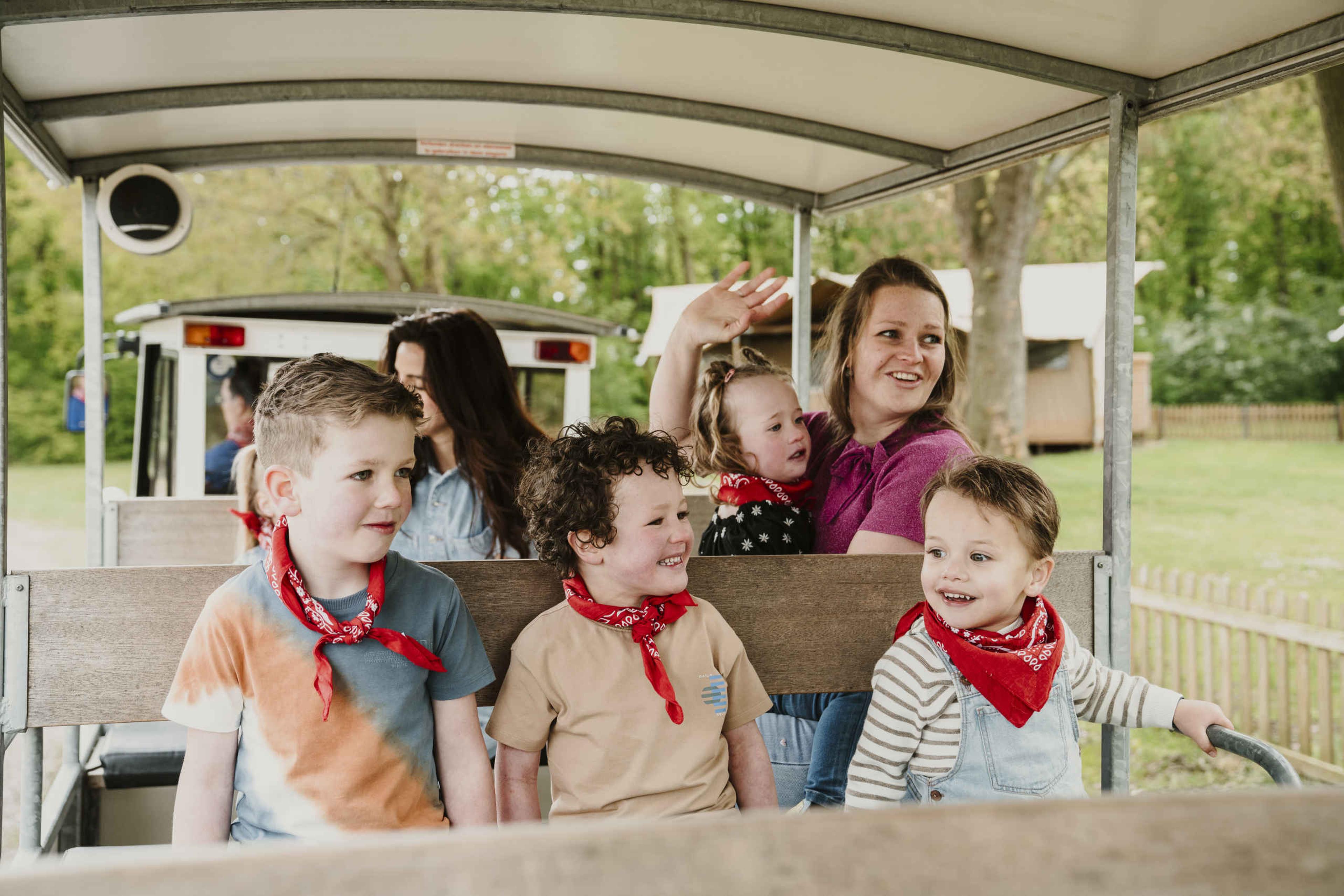 Een groep kinderen zit met hun ouders in het treintje bij Vakantiepark Dierenbos