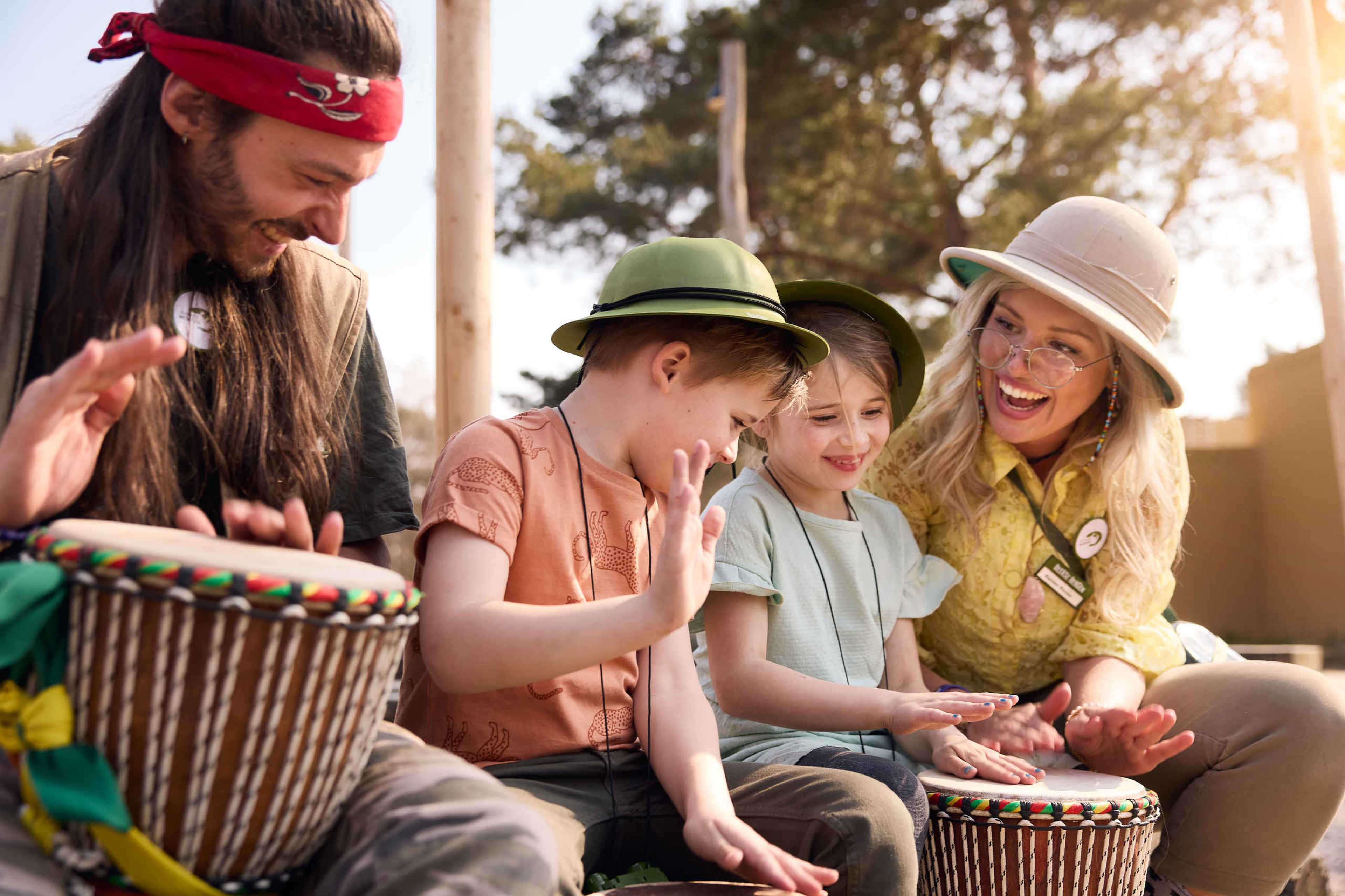 De rangers trommelen op een djembe samen met kinderen bij Safari Resort Beekse Bergen
