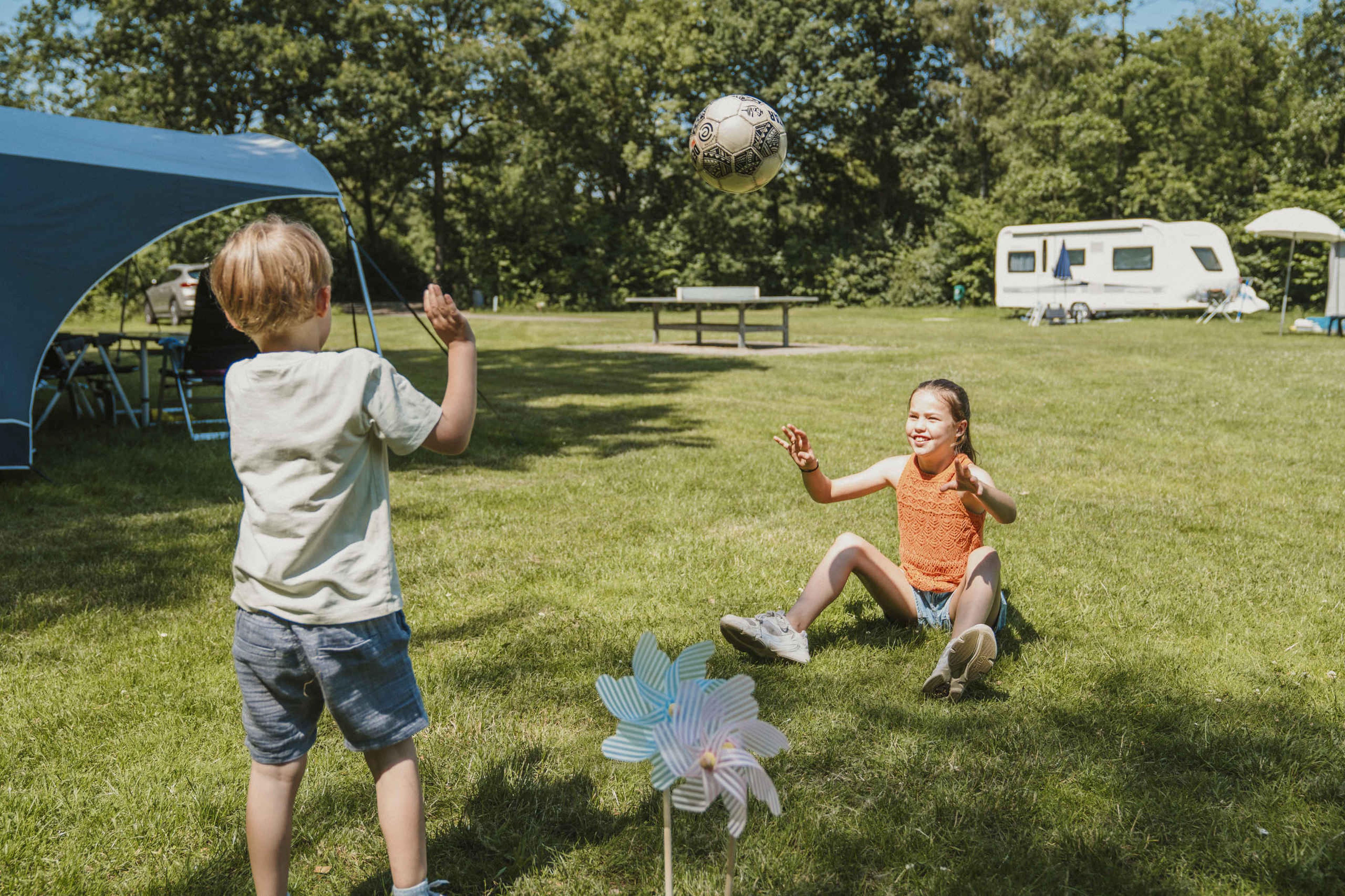 Twee kinderen spelen op de kampeerplaats bij Vakantiepark Dierenbos