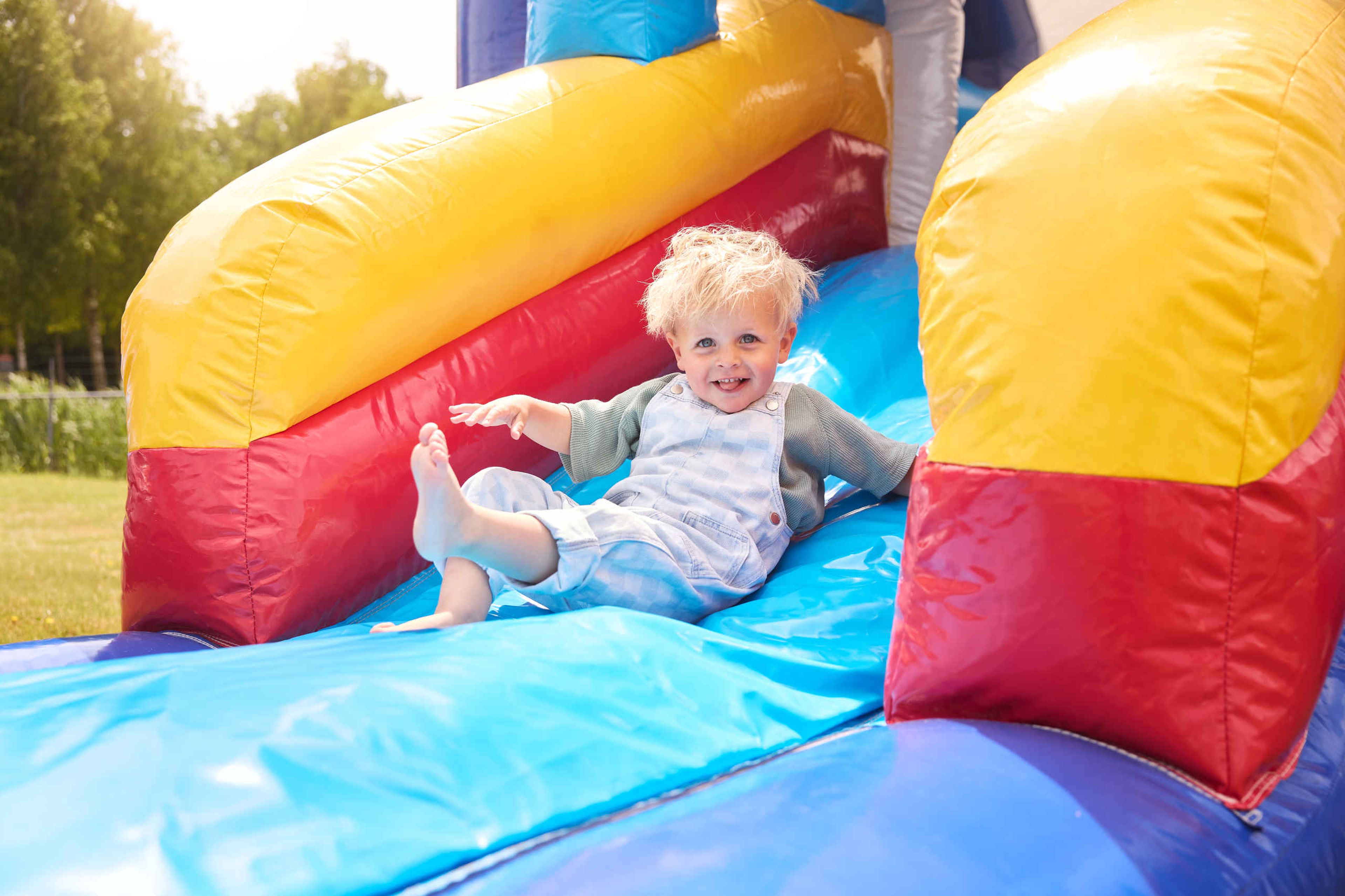 Een kind op de glijbaan van het springkussen bij Luchtvaartmuseum Aviodrome