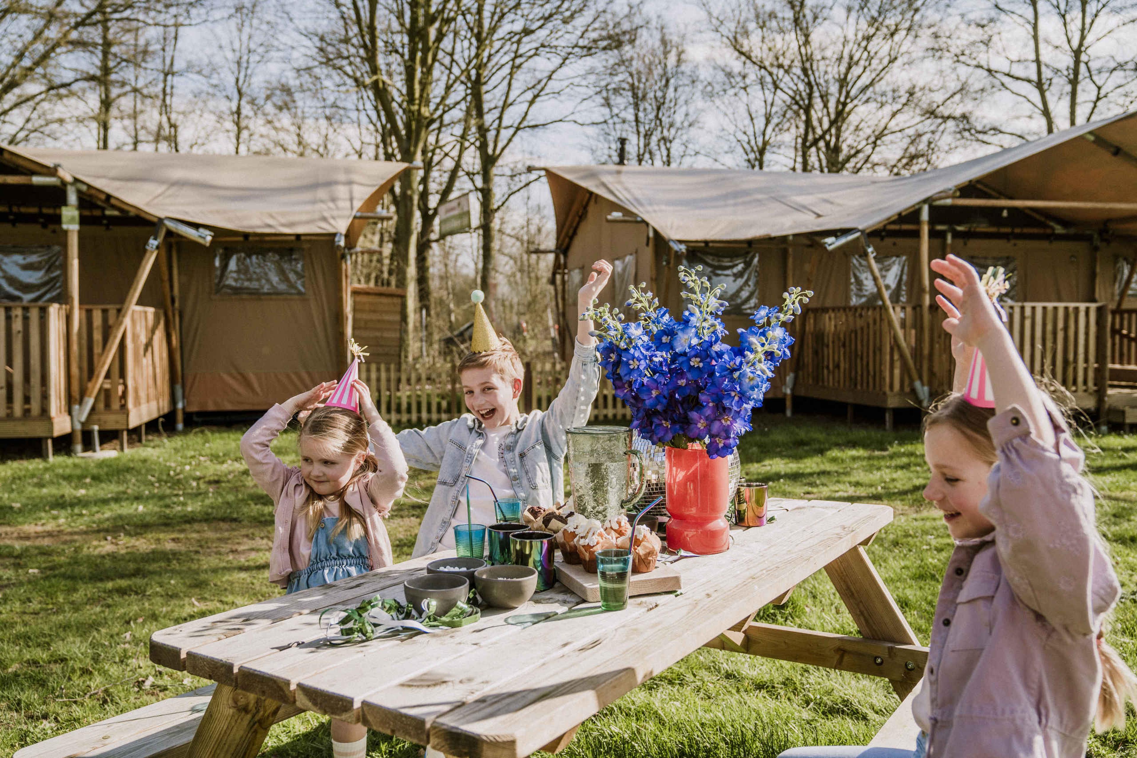 Kinderen aan een picknicktafel tijdens een kinderfeestje op Vakantiepark Dierenbos