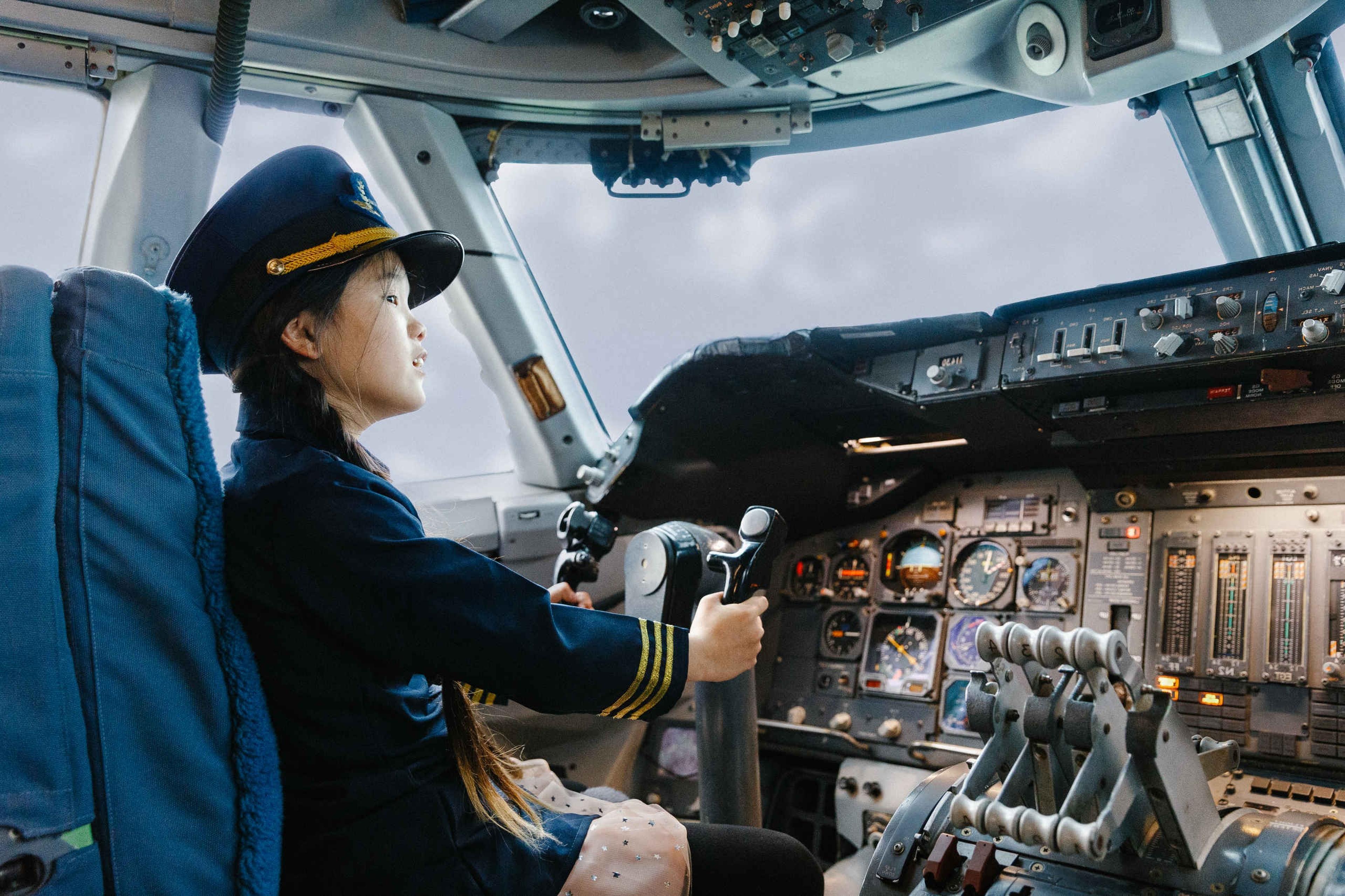 Een meisje zit in het vliegtuig bij luchtvaartmuseum Aviodrome.