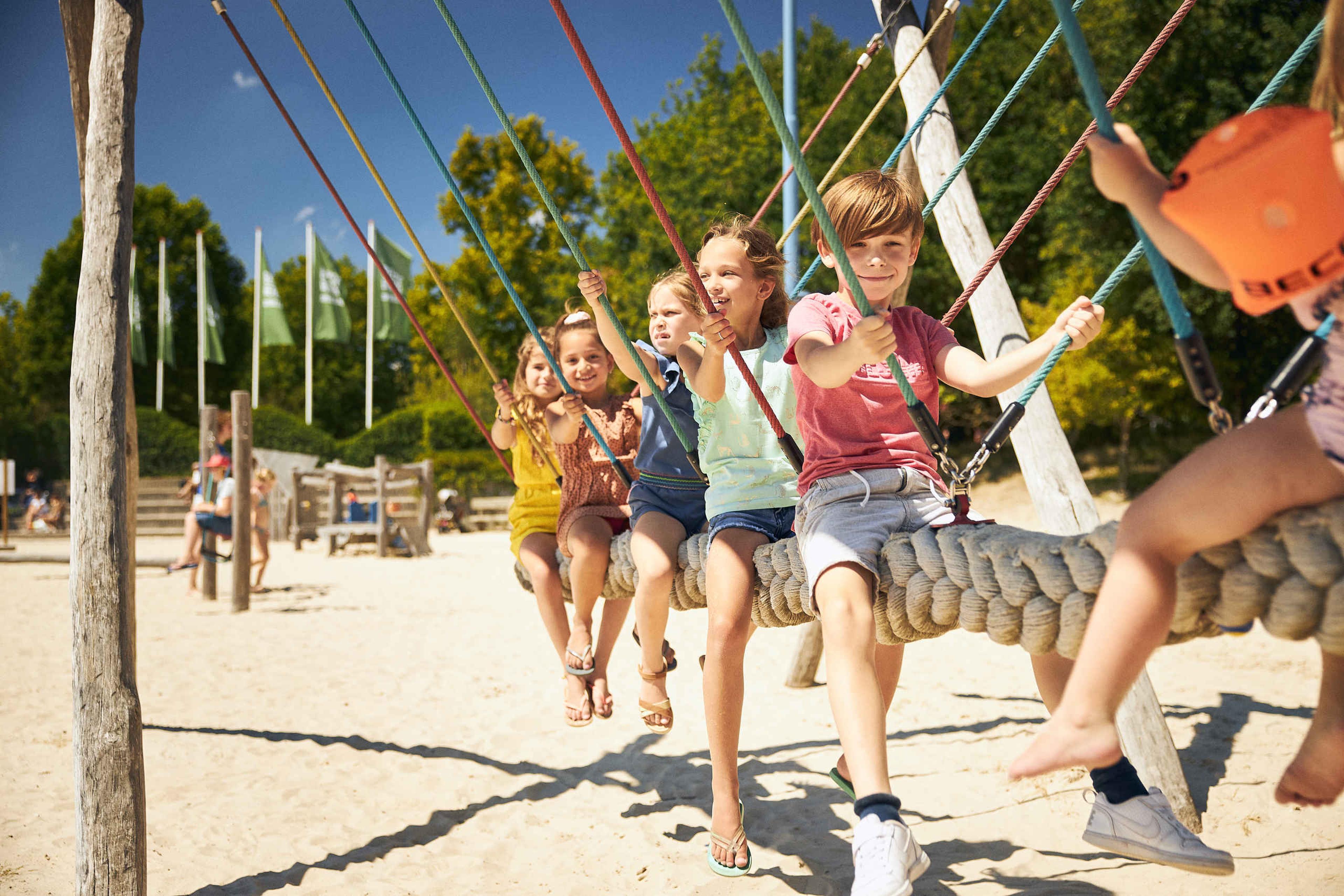 Kinderen schommelen op grote schommel in de speeltuin van Speelland Beekse Bergen