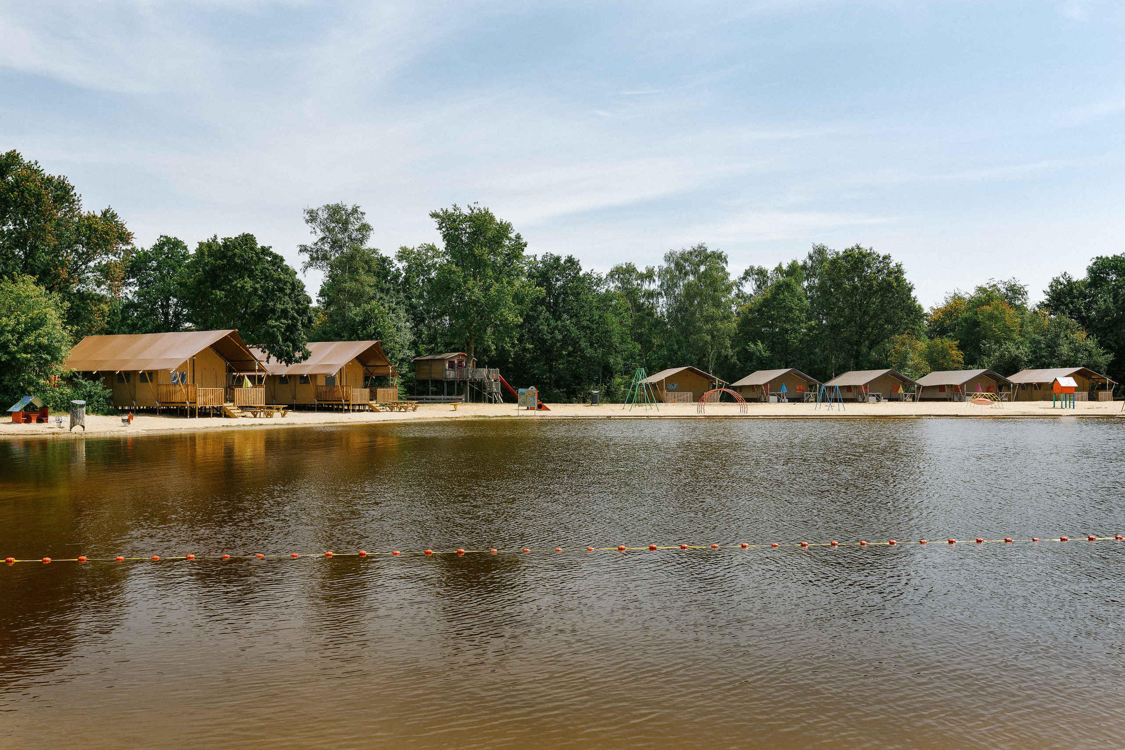 Zwemvijver en Luxe Lodgetent Pauw Plus op Vakantiepark Dierenbos