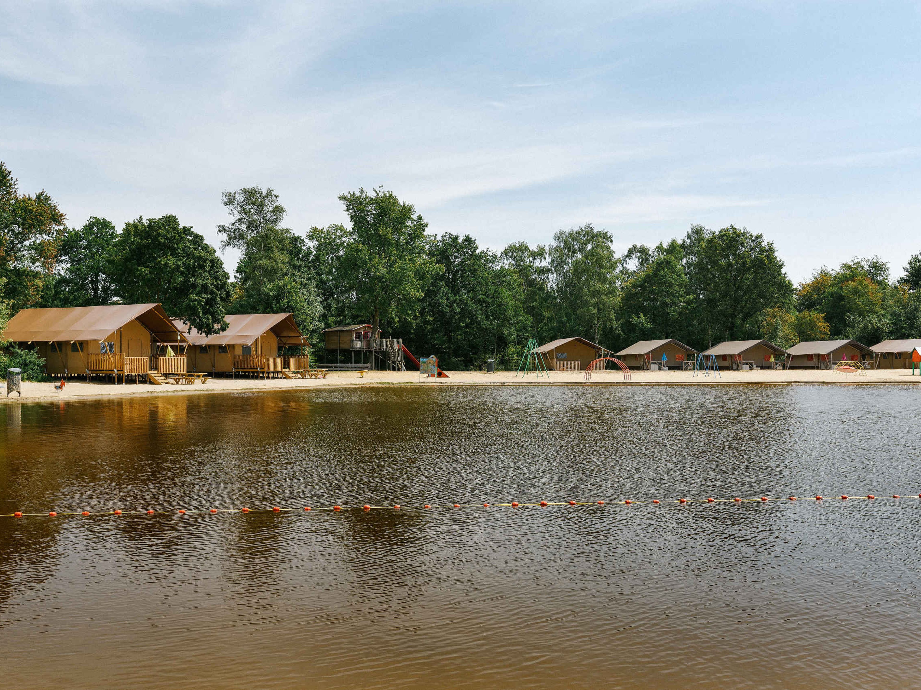 Zwemvijver en Luxe Lodgetent Pauw Plus op Vakantiepark Dierenbos