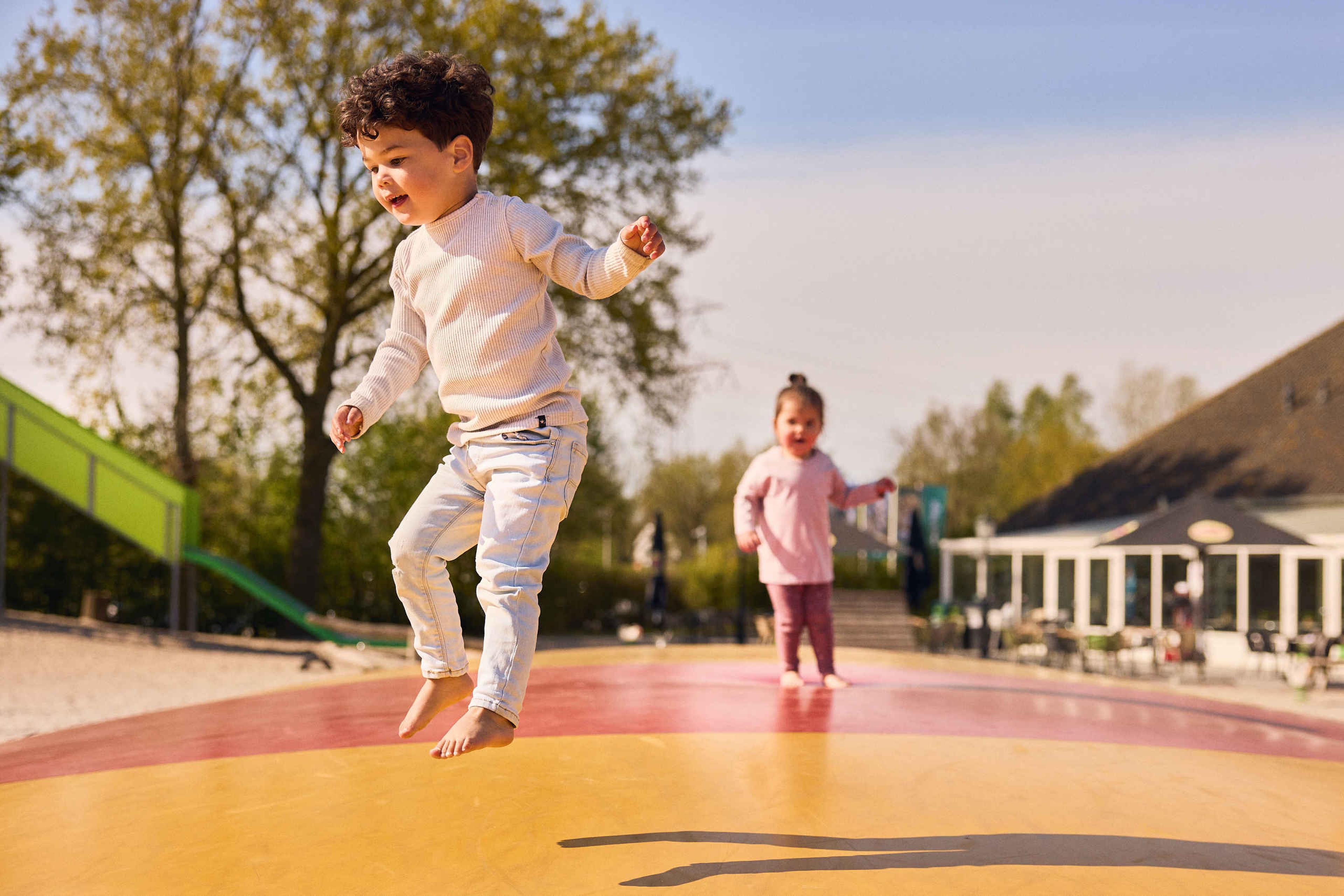 Twee kinderen springen op de airtrampoline in de speeltuin in Eindhoven Zoo.