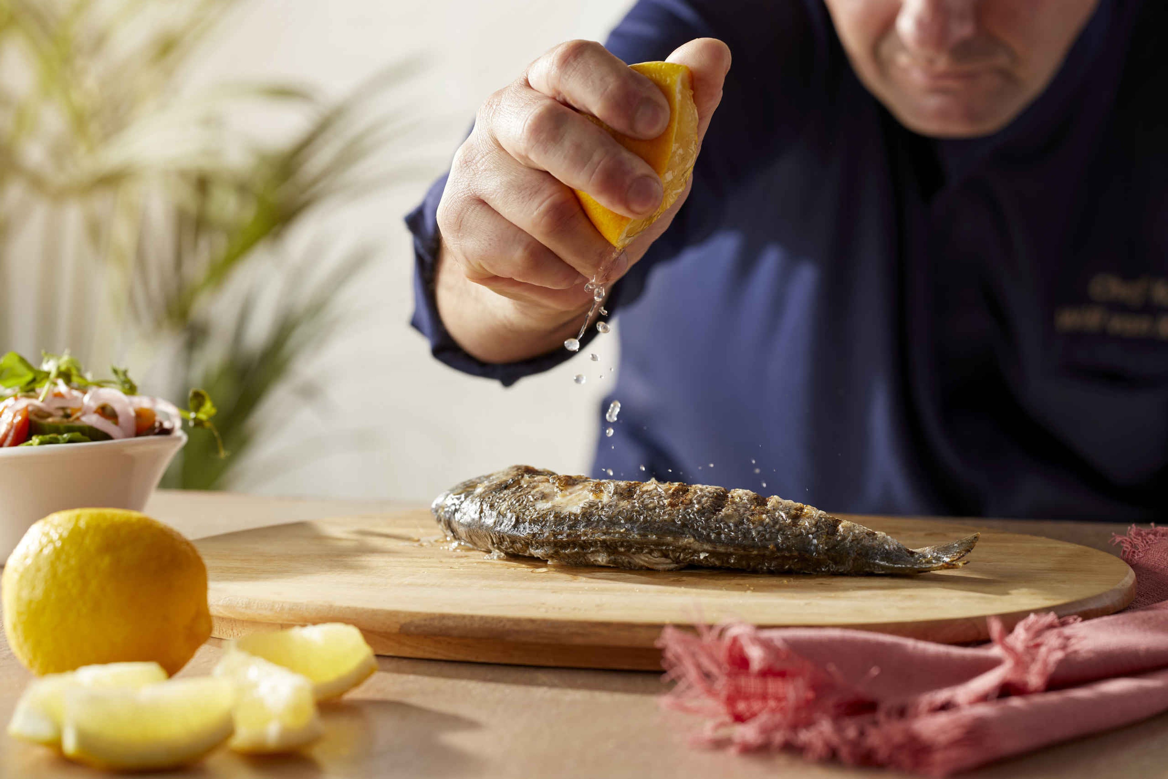 De chefkok bereidt een visgerecht met citroen bij restaurant Labadi op Lake Resort Beekse Bergen.