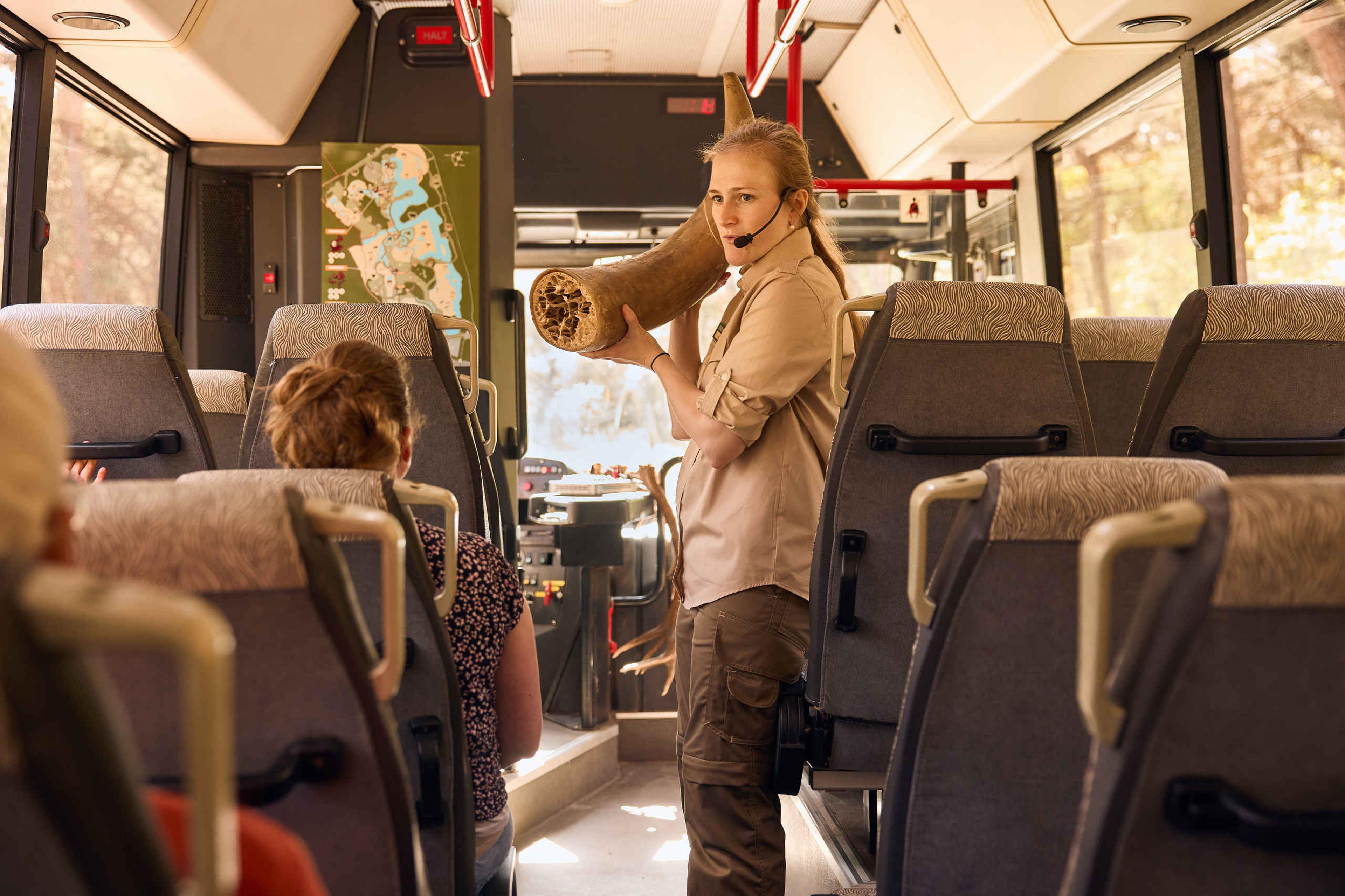 Educatiemedewerker met een hoorn tijdens de bussafari in Safaripark Beekse Bergen