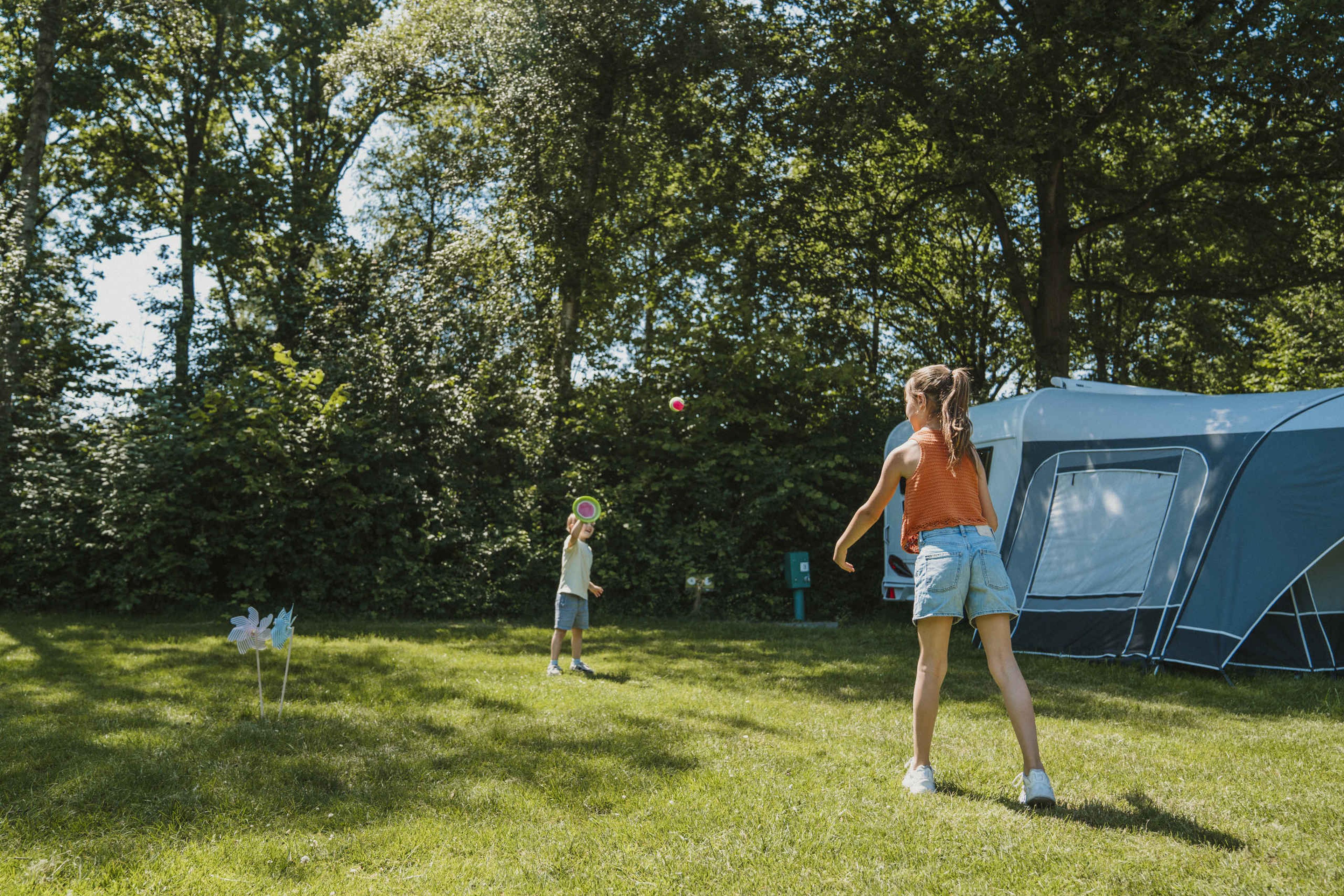 Twee kinderen tennissen op de kampeerplaats bij Vakantiepark Dierenbos