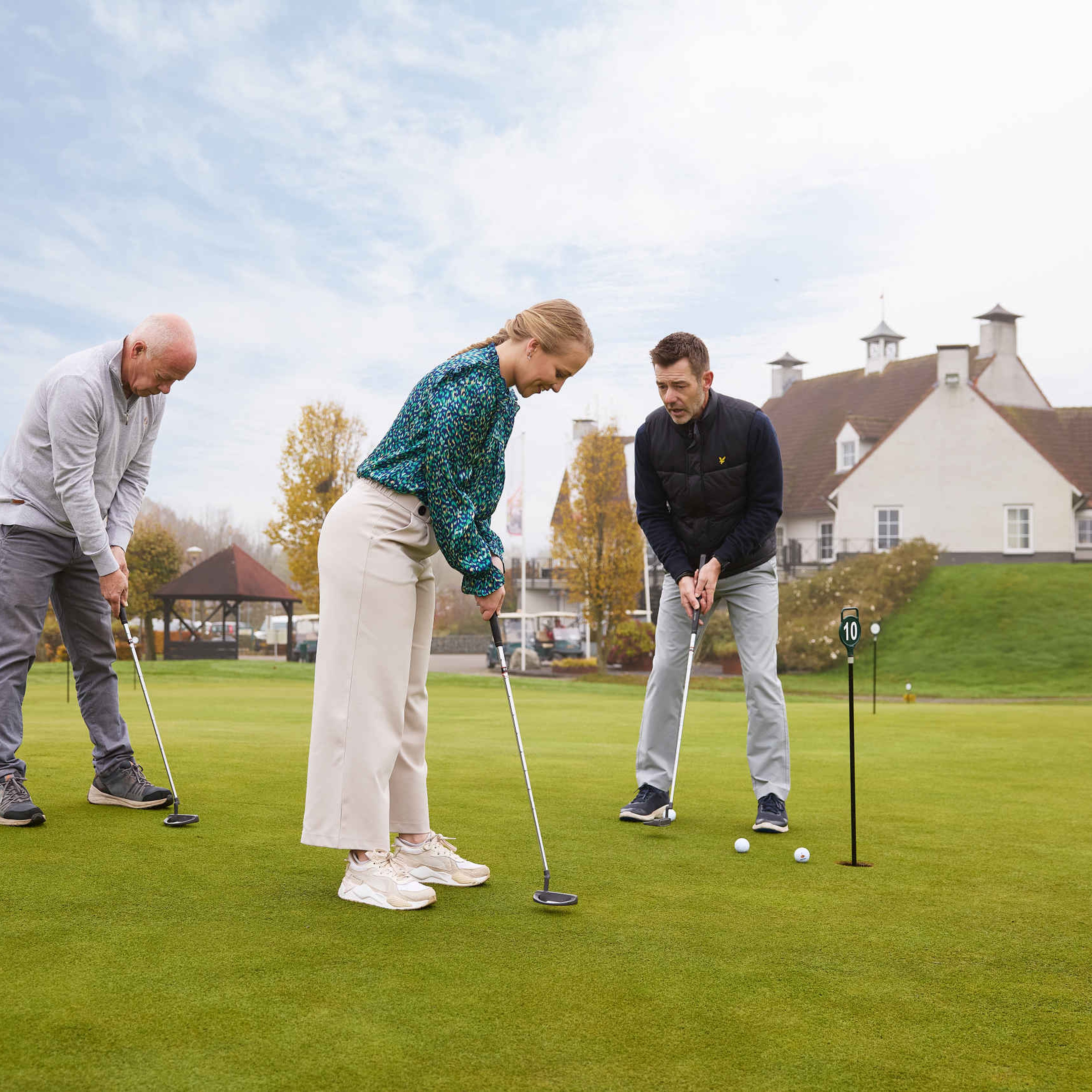 Instructeur putten man vrouw puttinggreen Golf De Gulbergen