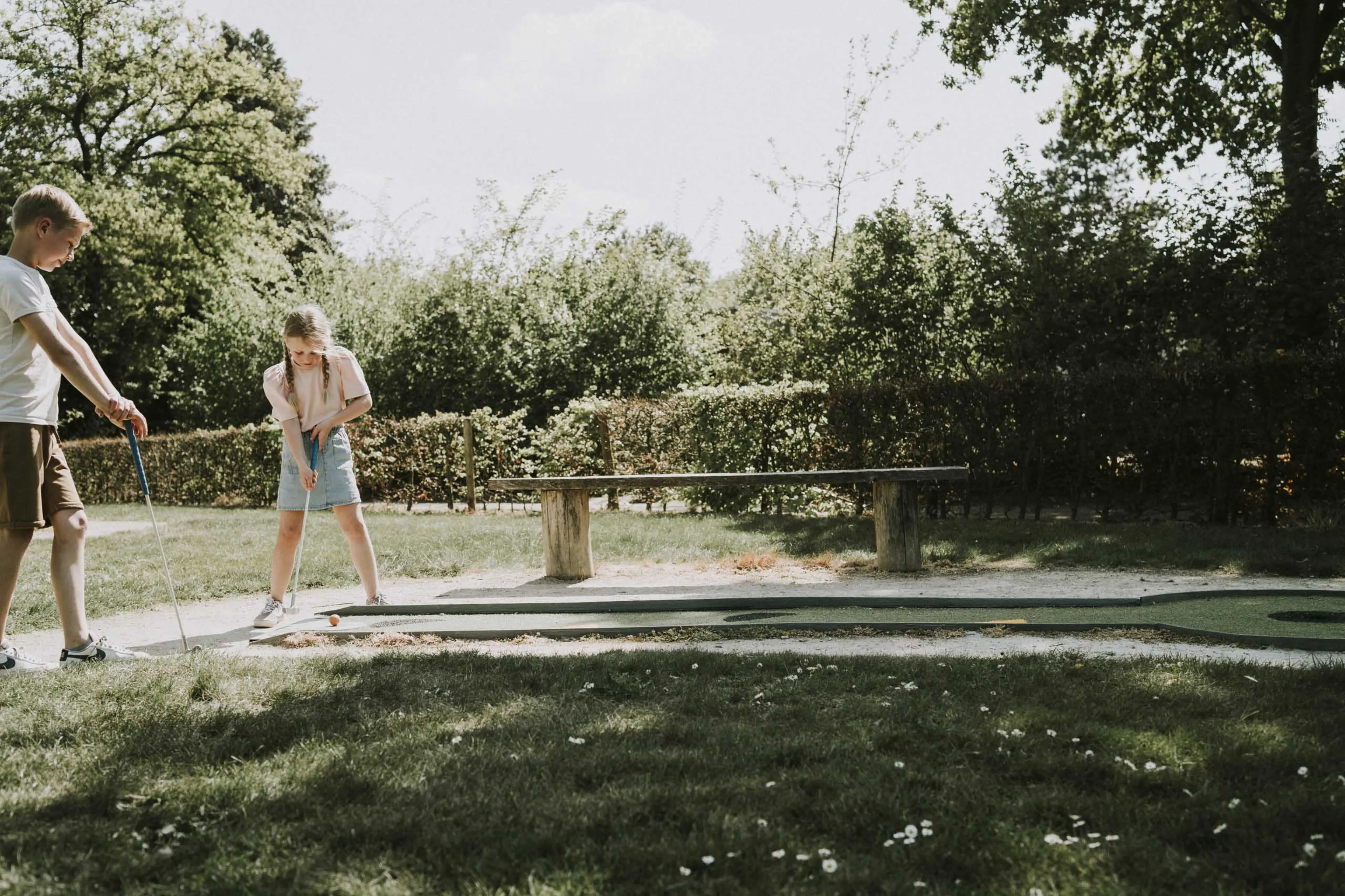 Jongen en meisje aan het midgetgolfen op de midgetgolfbaan van Vakantiepark Dierenbos