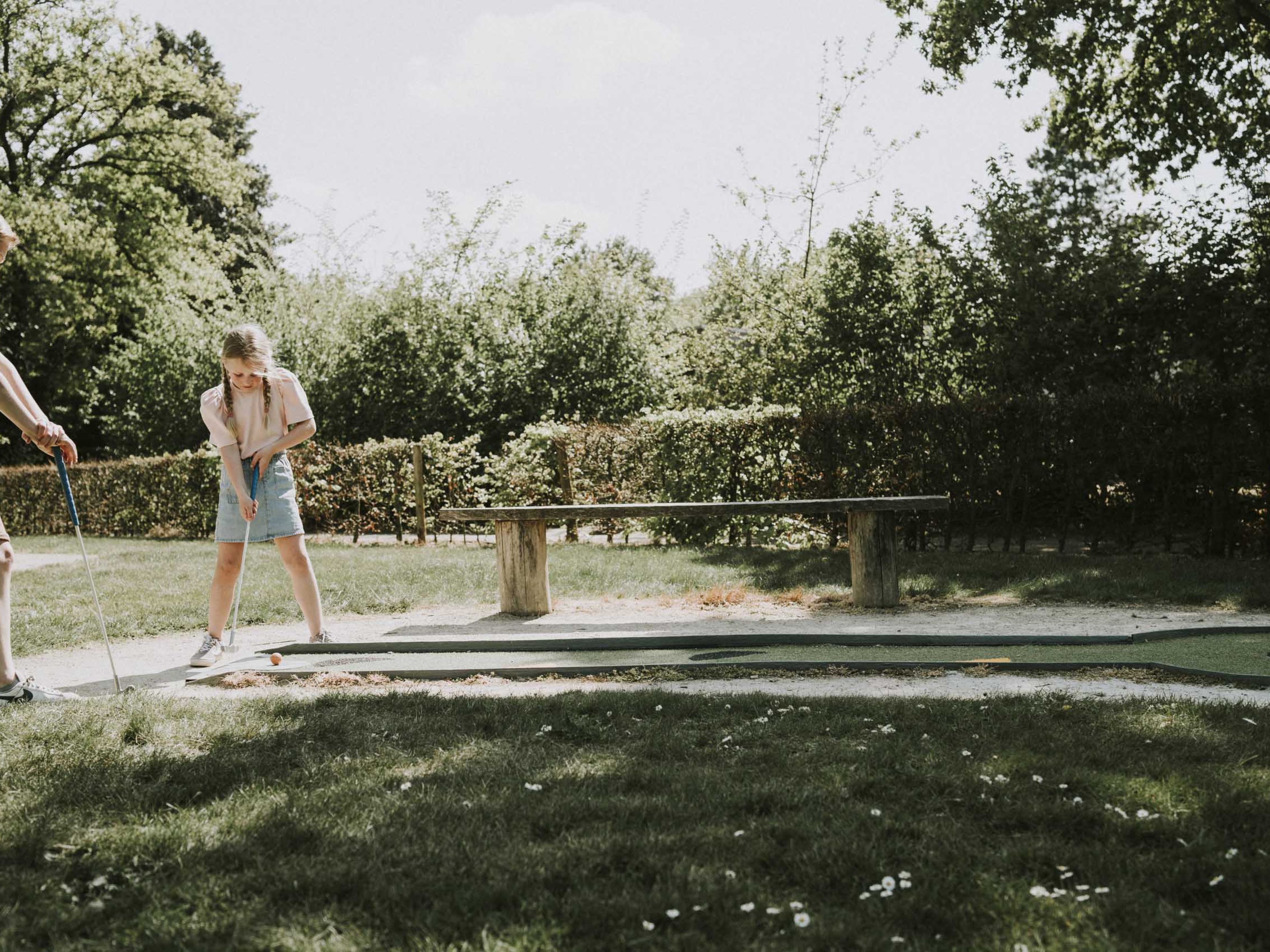 Jongen en meisje aan het midgetgolfen op de midgetgolfbaan van Vakantiepark Dierenbos