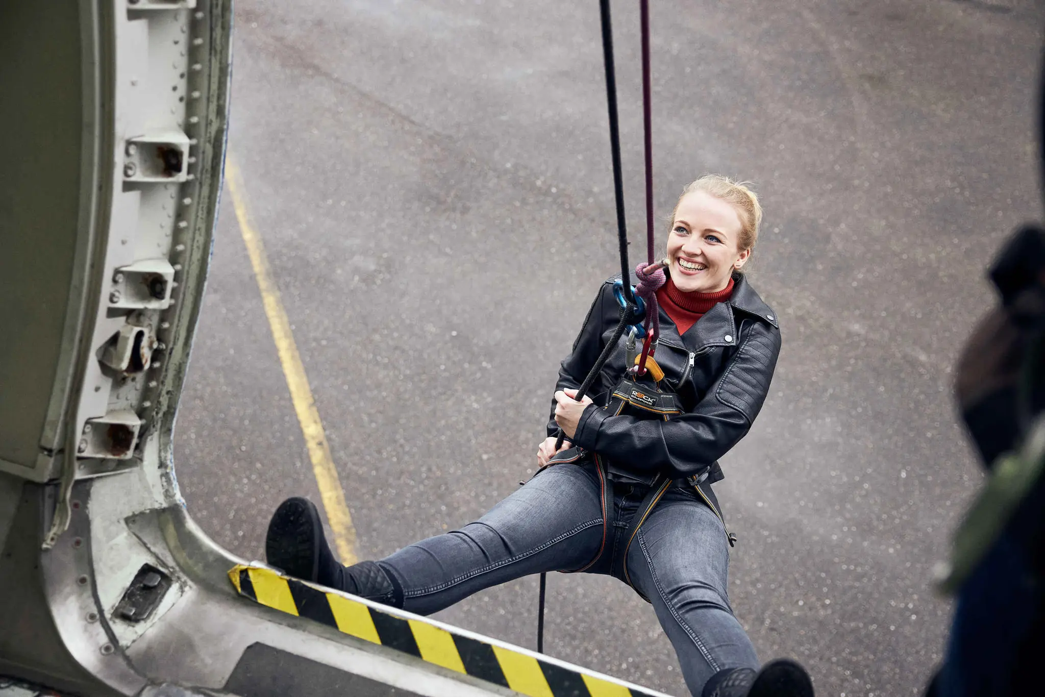 Een vrouw gaat abseilen vanuit een vliegtuig tijdens een zakelijk activiteit bij Aviodrome