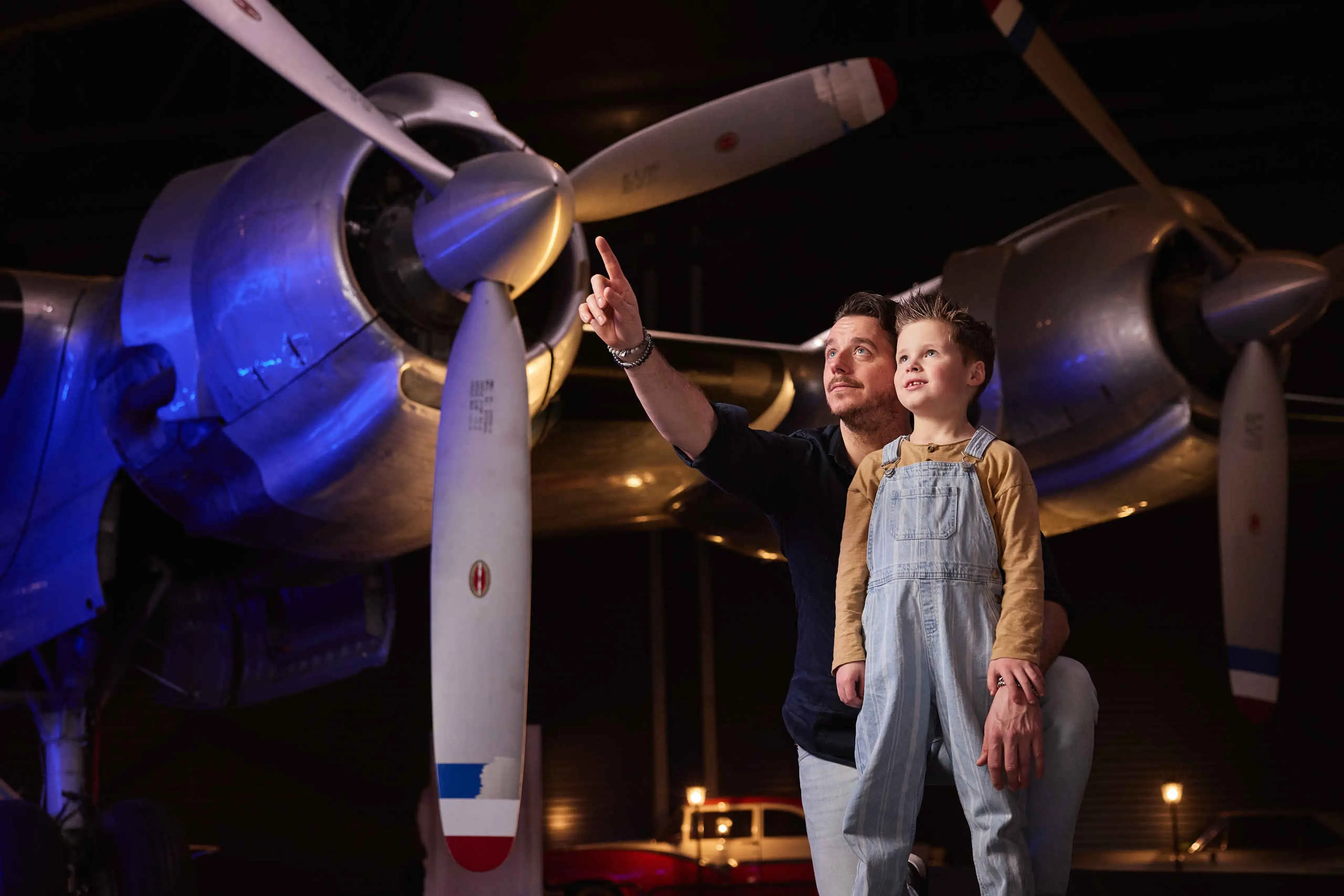 Een vader en zoon bewonderen de binnenexpositie van Luchtvaartmuseum Aviodrome