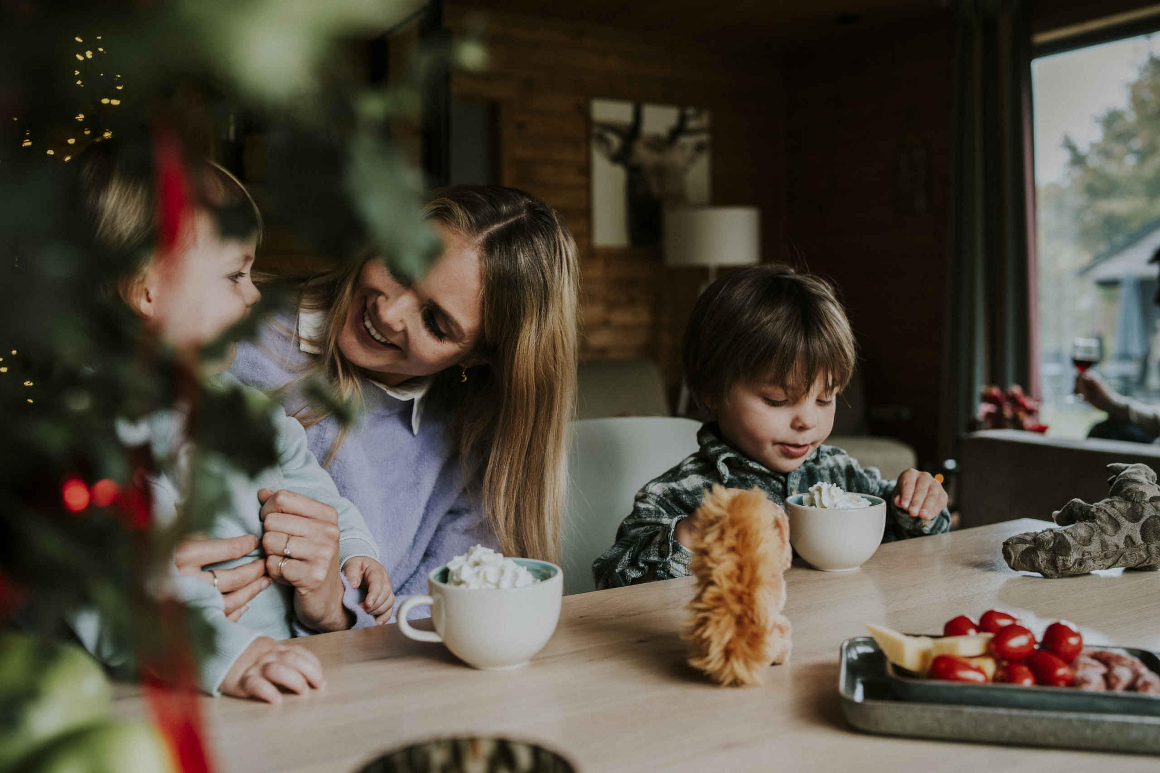 Moeder en kinderen drinken warme chocolademelk bij Vakantiepark Dierenbos