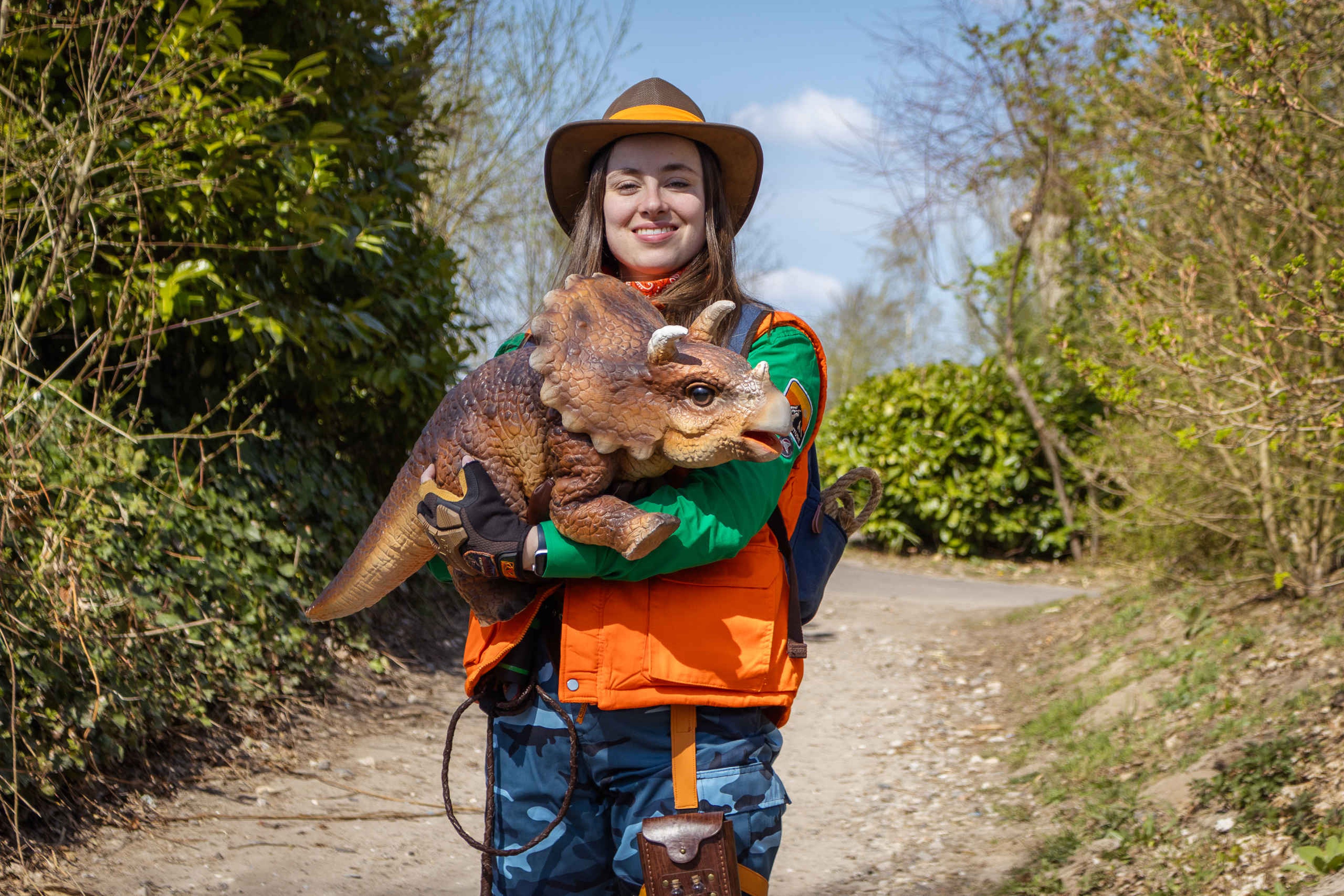 Een ranger met een baby triceratops bij DINO vs DIER in Eindhoven Zoo.