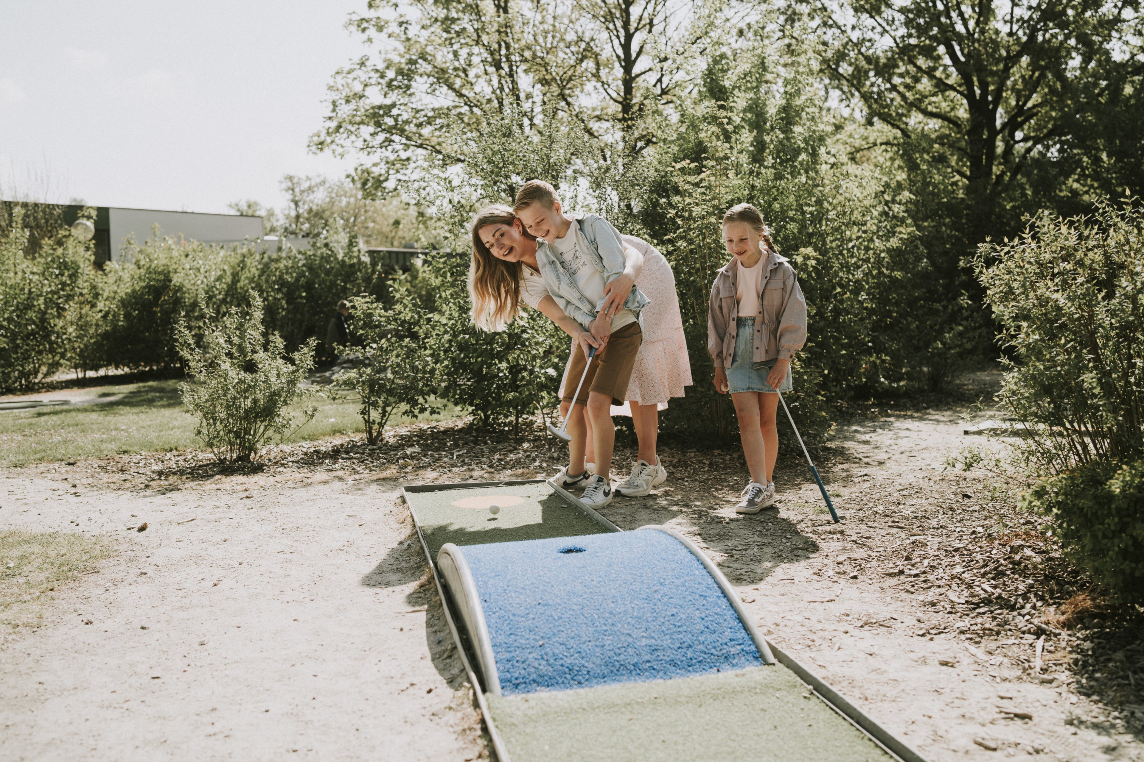 Moeder en kinderen spelen midgetgolf bij Vakantiepark Dierenbos