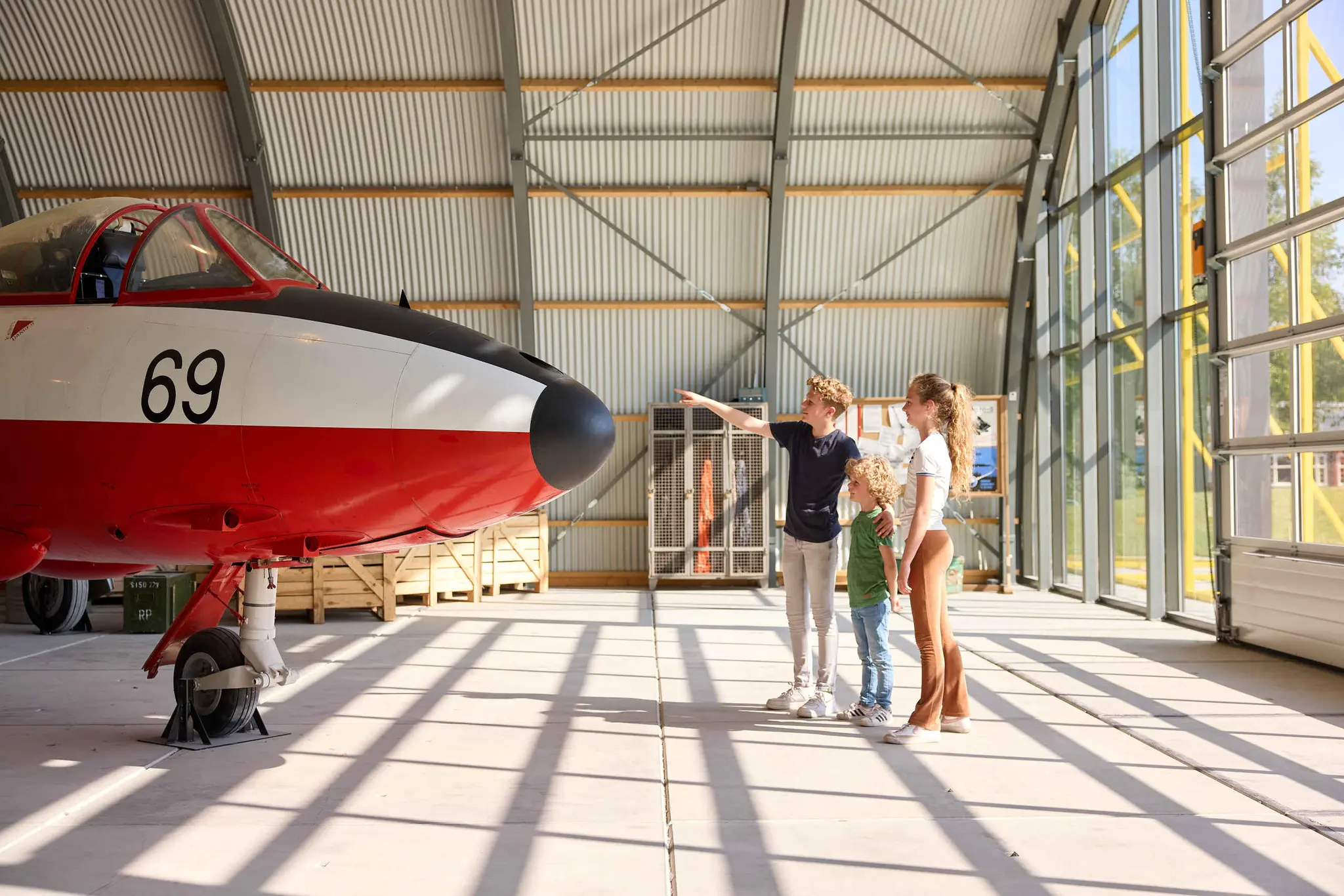 Kinderen straaljagerexpositie wijzen naar vliegtuig Luchtvaartmuseum Aviodrome